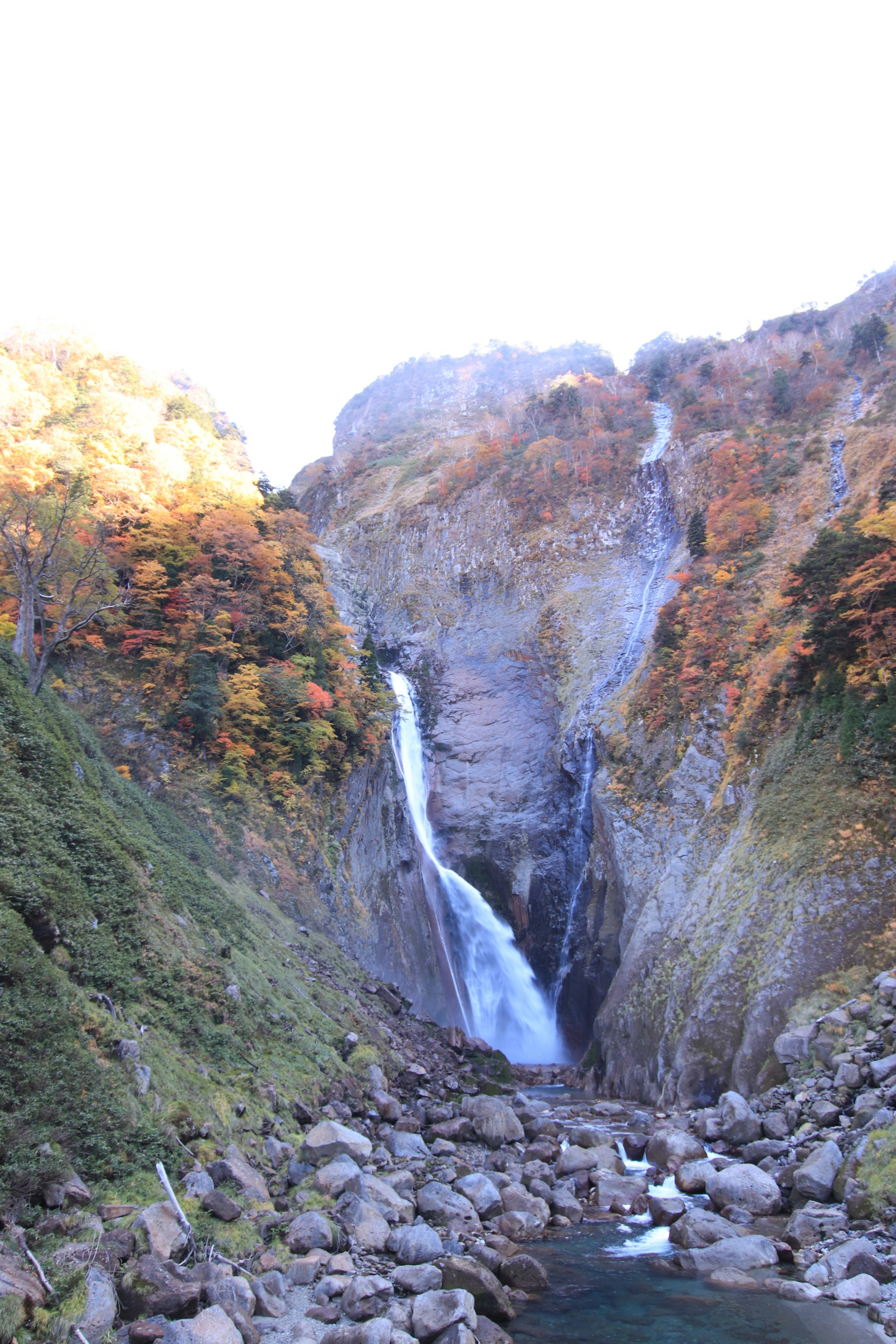 Ein schöner Wasserfall umgeben von herbstlichem Laub