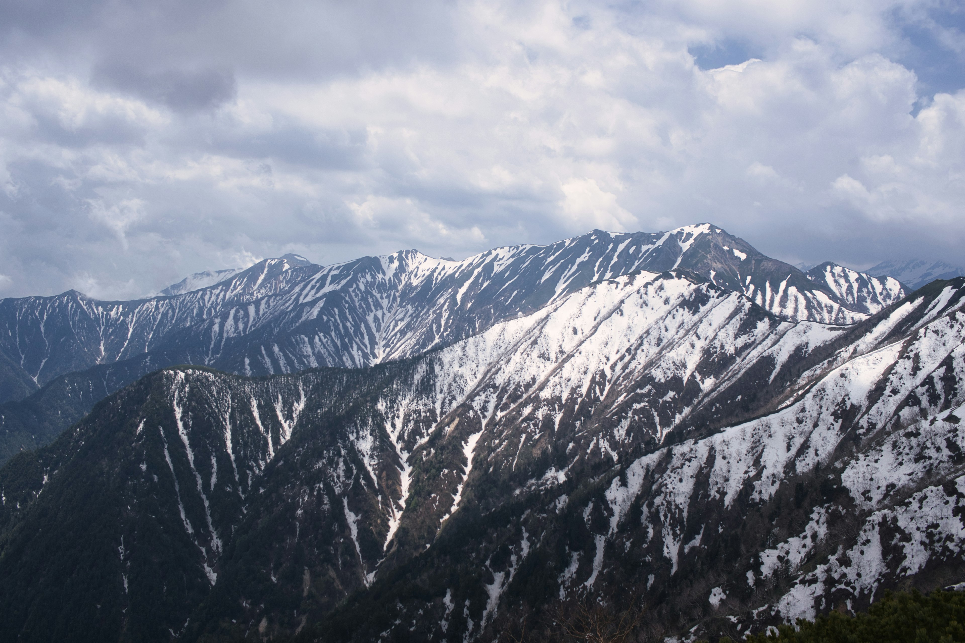 Montagnes enneigées sous un ciel nuageux