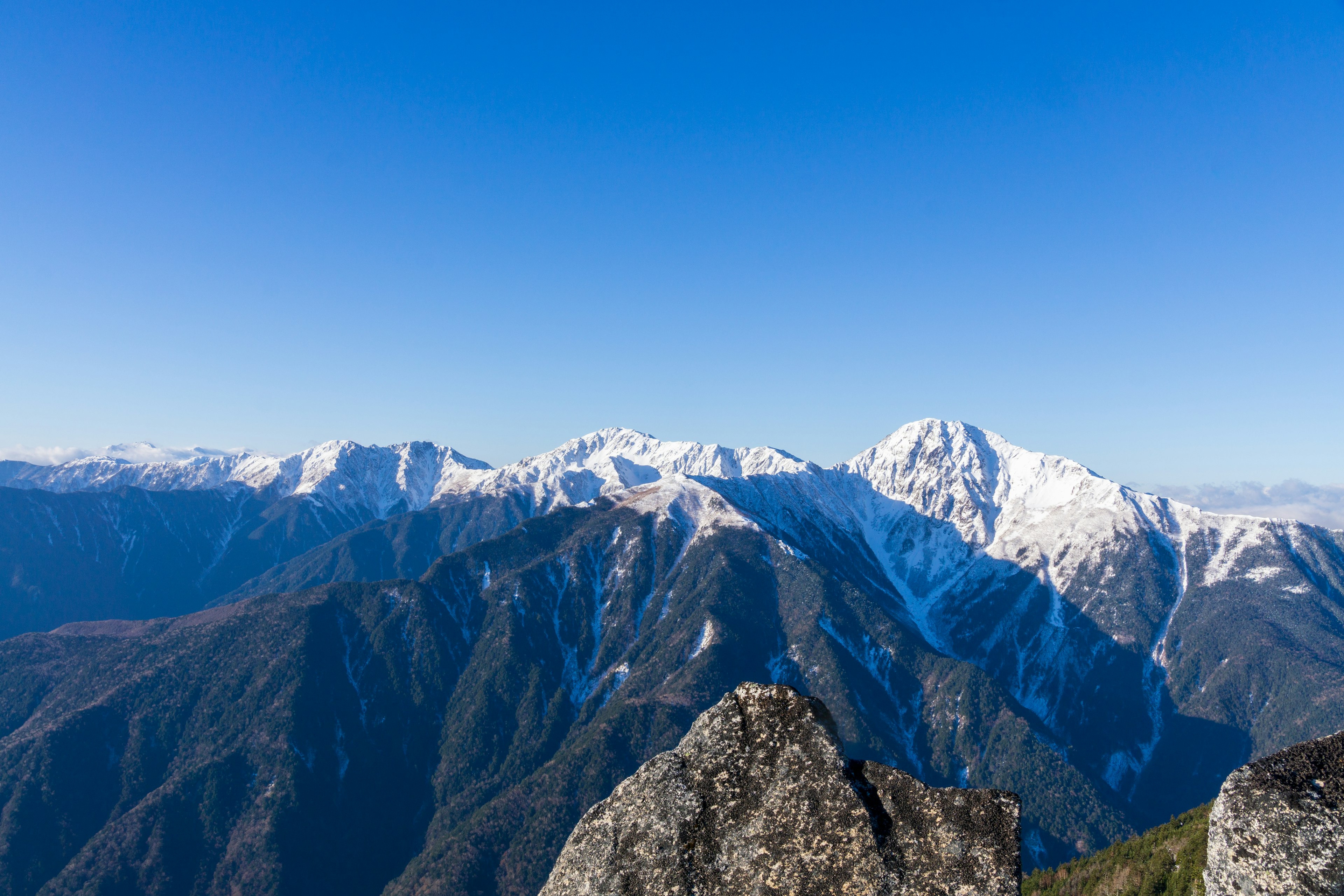 Montagne innevate sotto un cielo blu chiaro