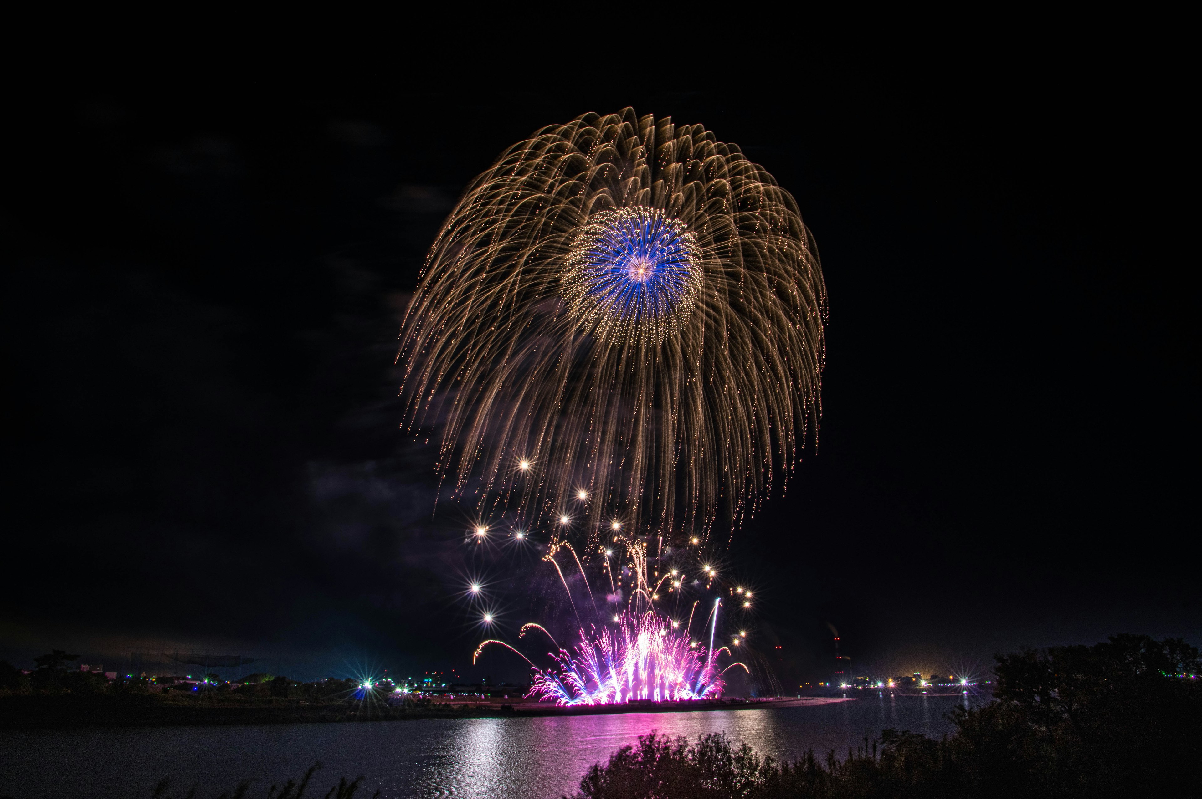 夜空中绽放的绚丽烟花映衬水面