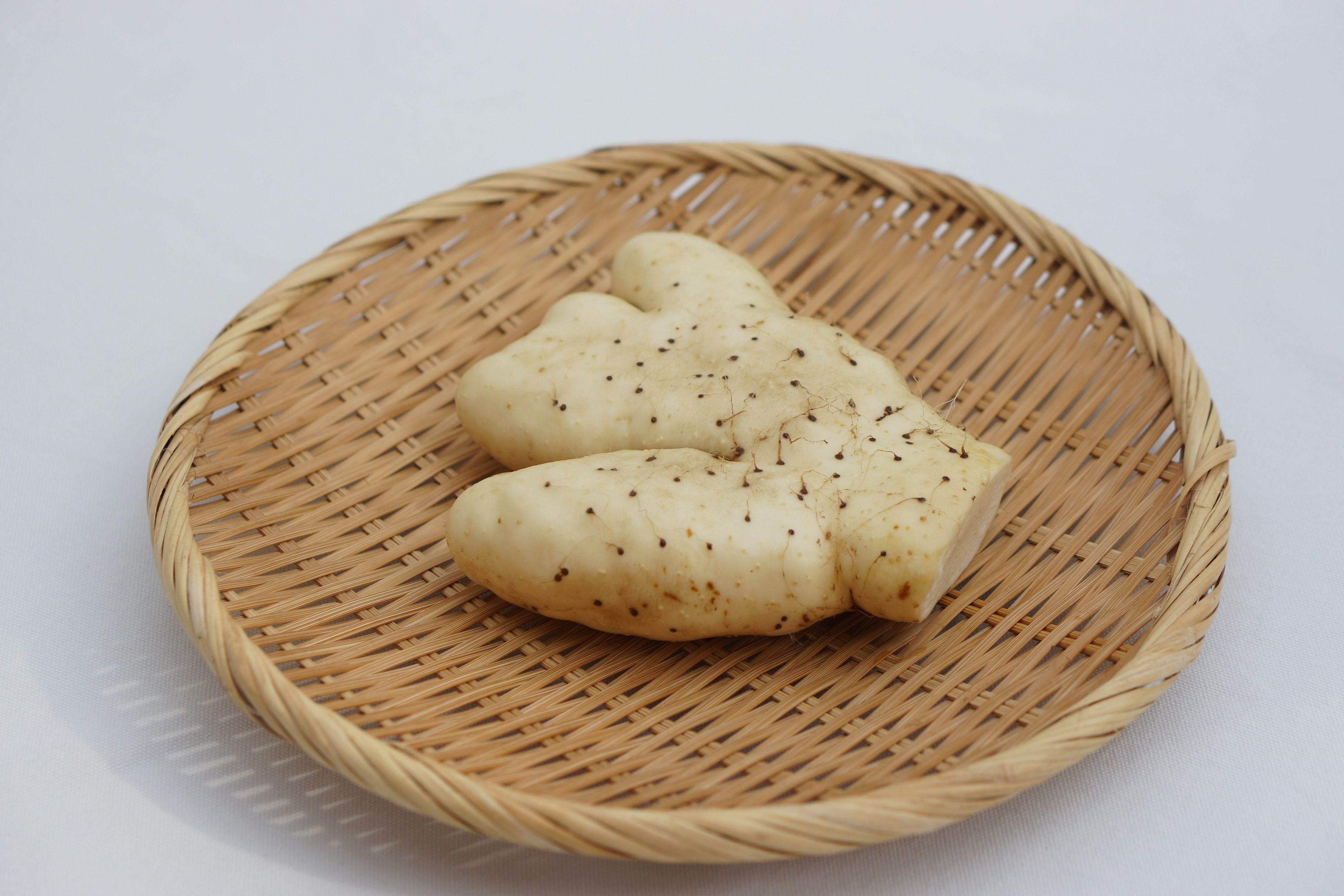 A soft bread with a unique shape resting on a woven basket