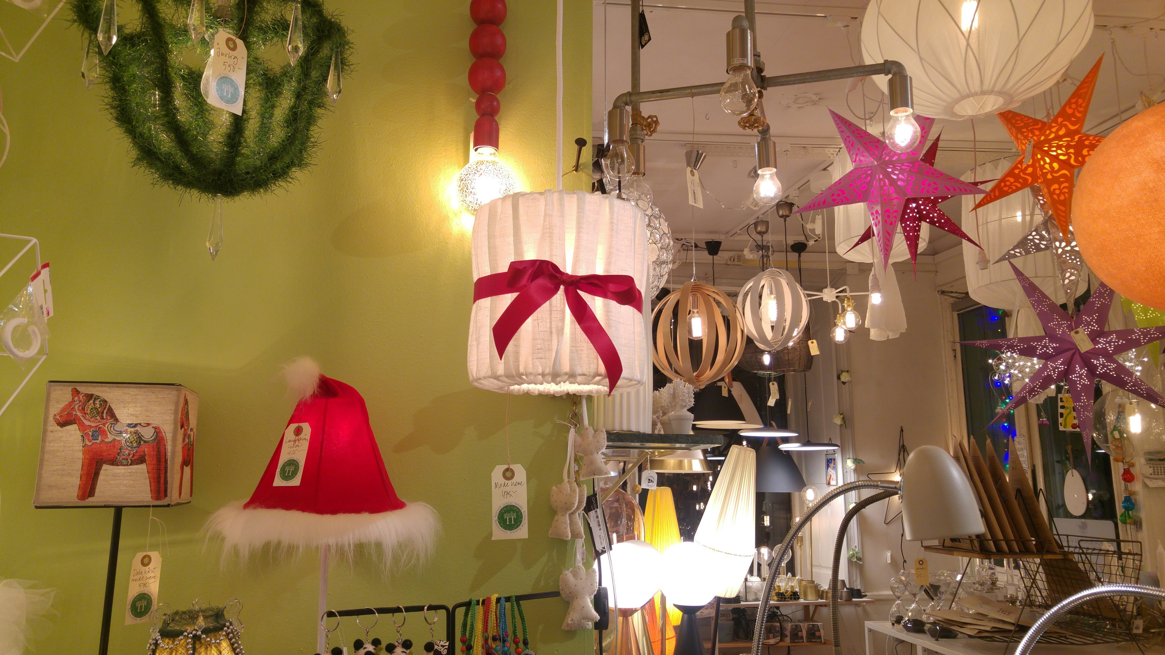 Colorful lamps and Christmas hats hanging on a green wall