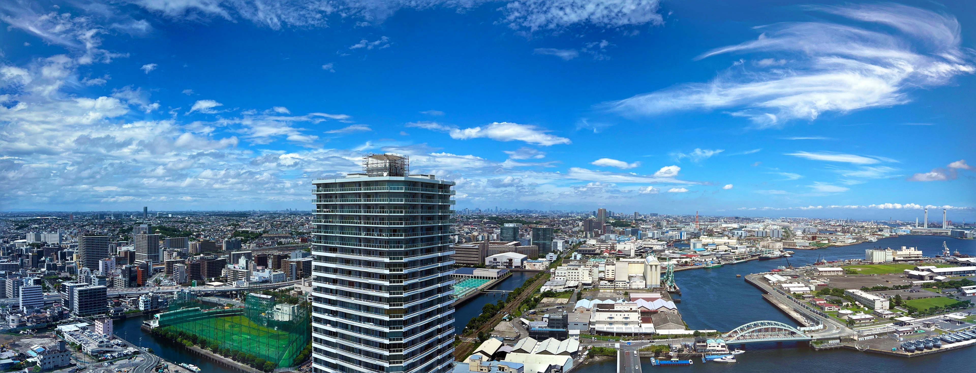 都市のパノラマ景観、青空と雲、ビル群、川が見える