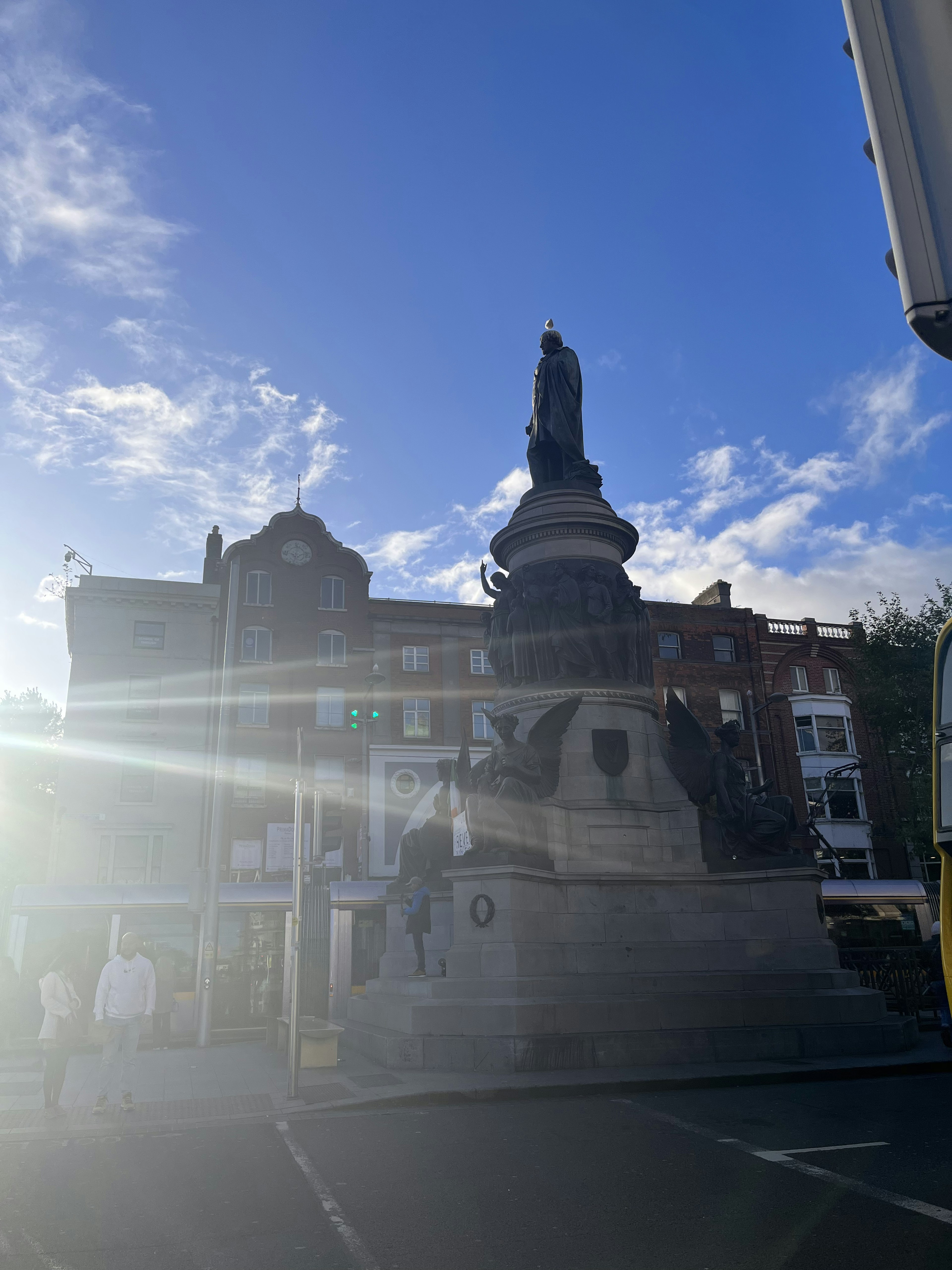 Estatua monumental con edificios bajo un cielo azul claro