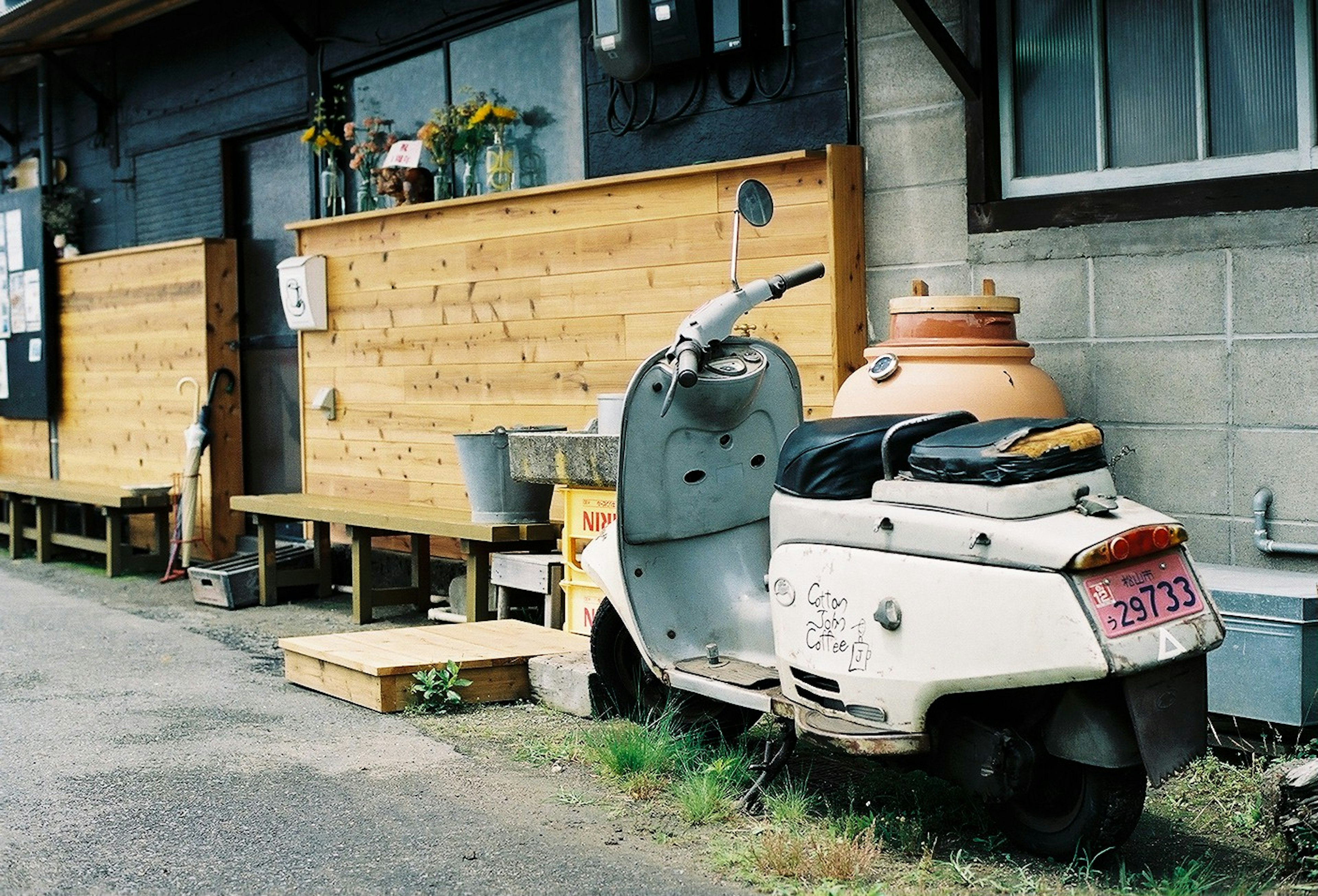 古いスクーターと木製の壁がある静かな通りの風景