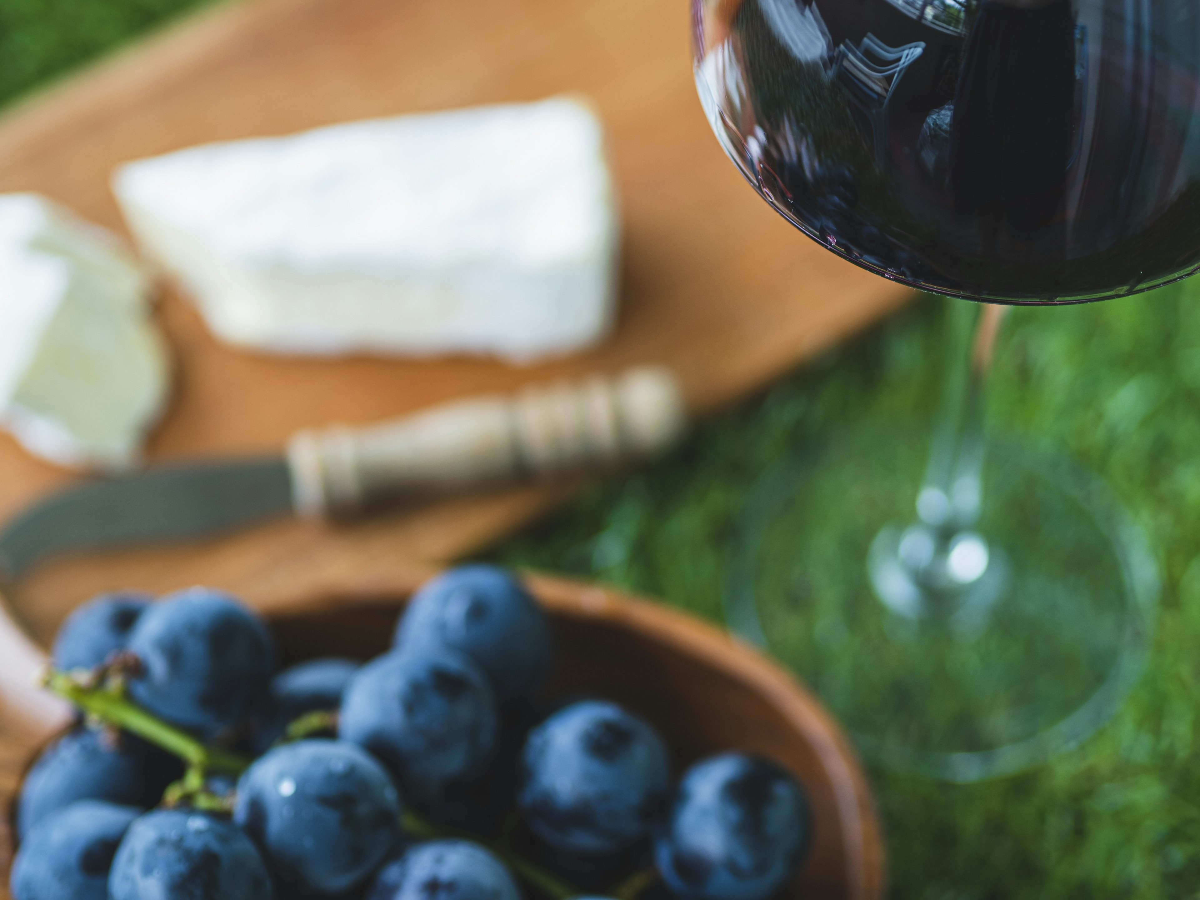 A beautiful plate featuring red wine, fresh blueberries, and cheese