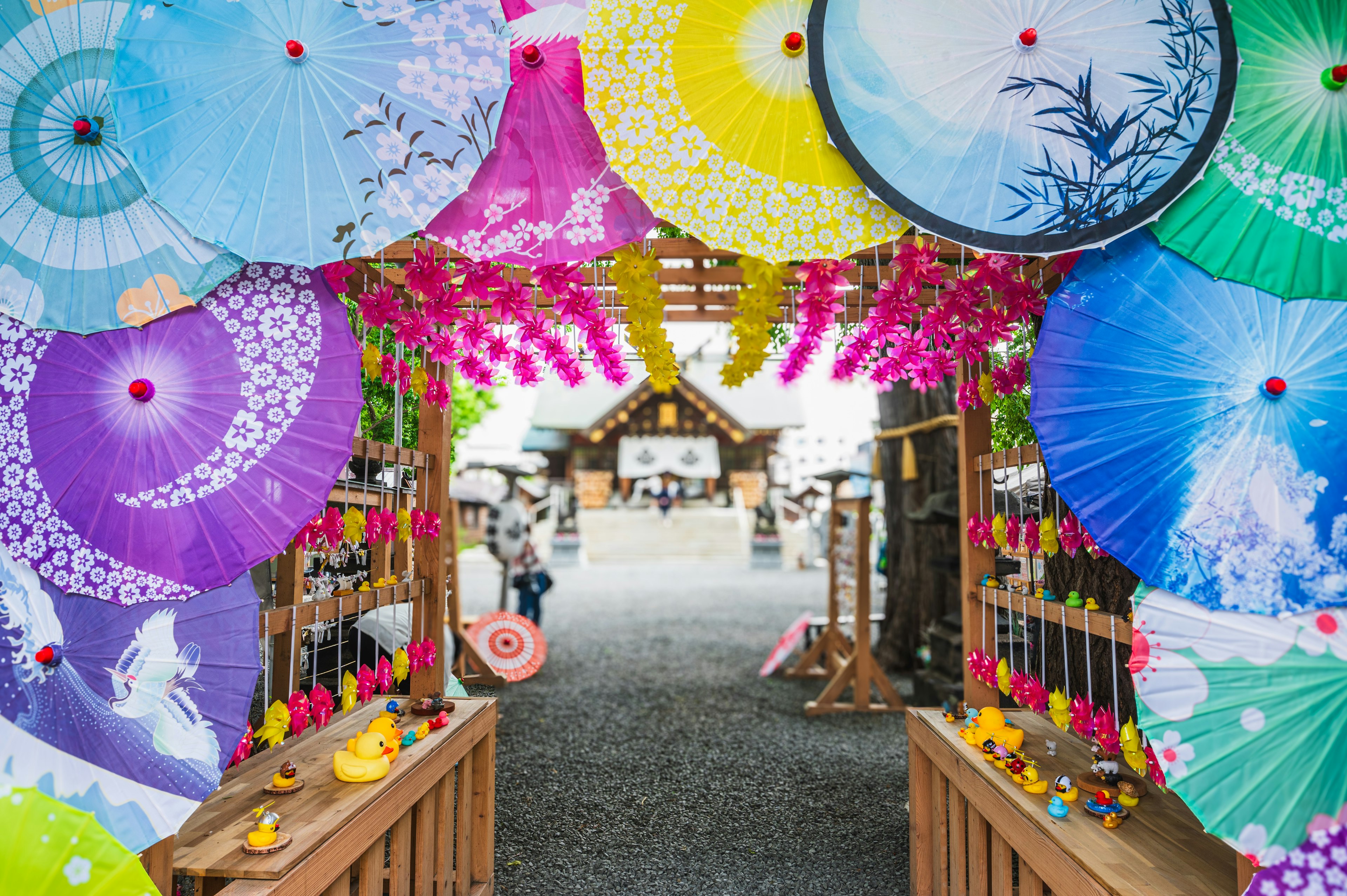 Parapluies colorés décorant une entrée avec des fleurs et des décorations