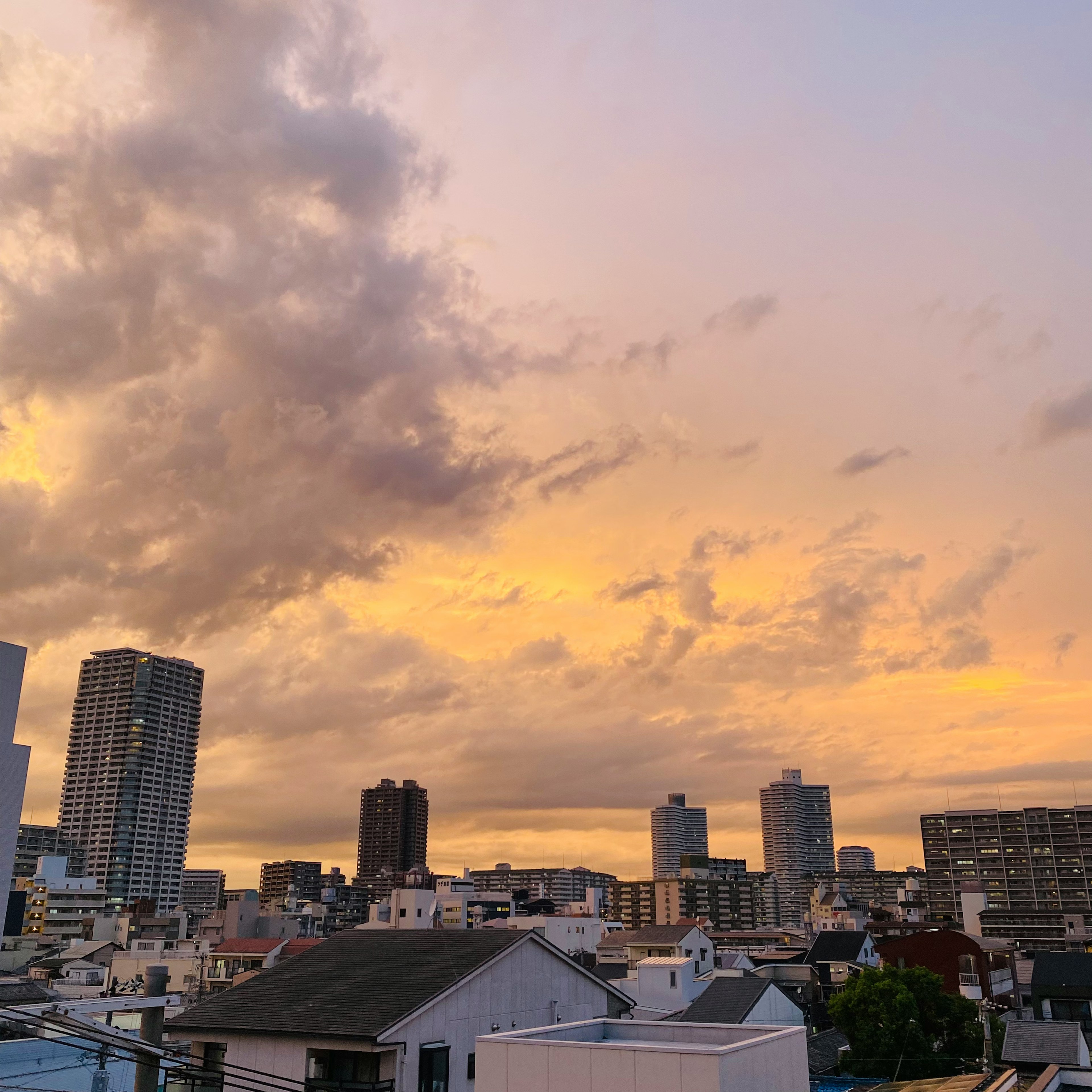 夕焼けの空と都市の風景高層ビルと雲が広がる