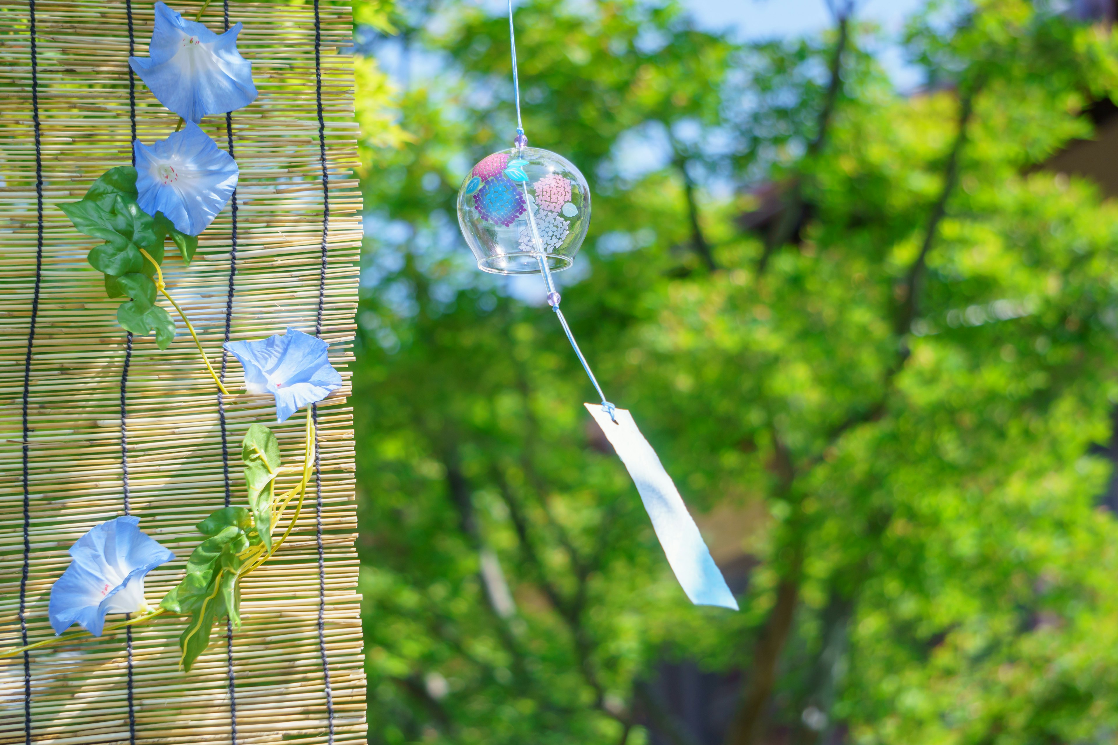 Sommerlandschaft mit einem Windspiel und grünen Blättern