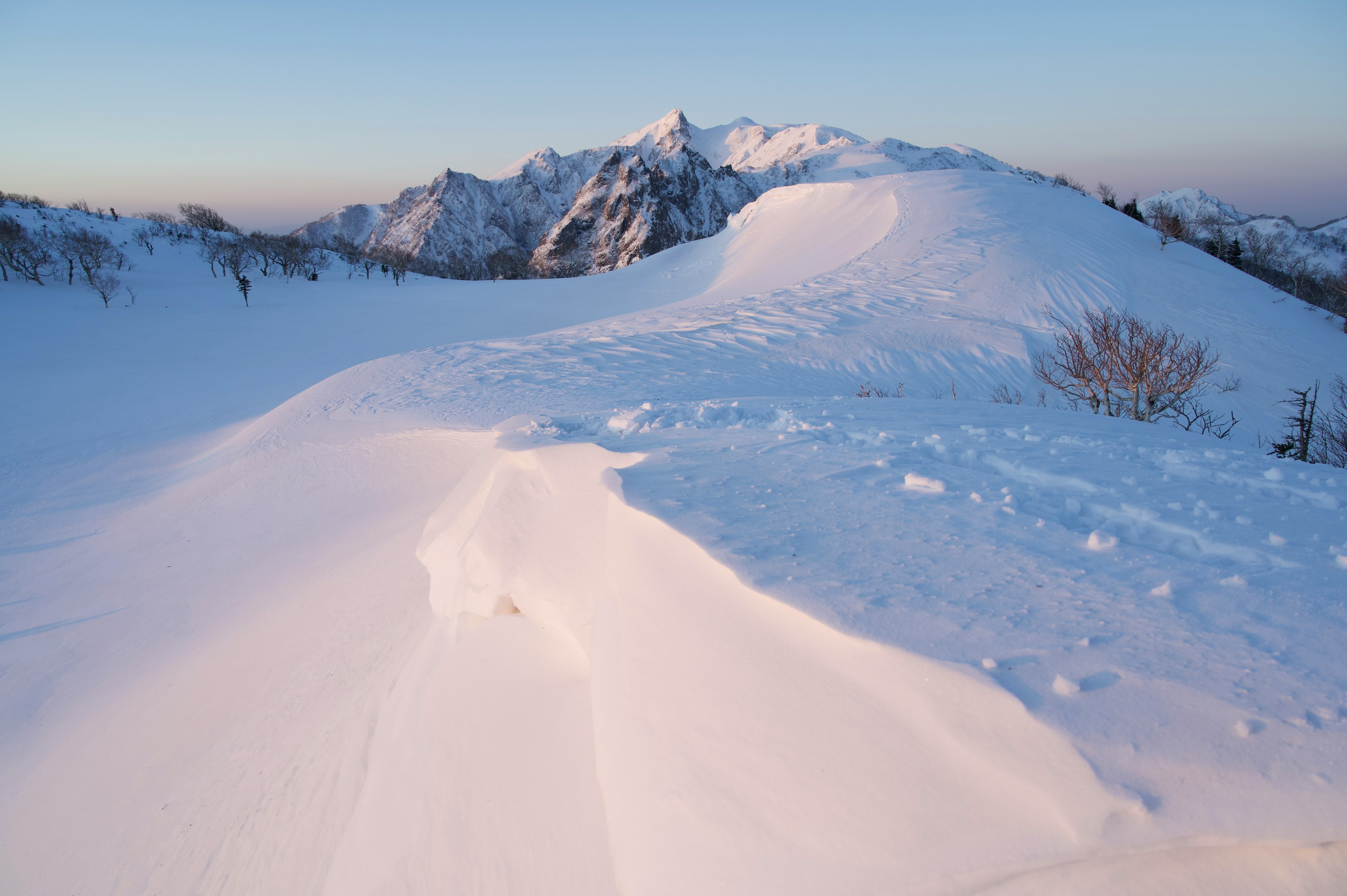 Paesaggio montano innevato con cielo blu chiaro