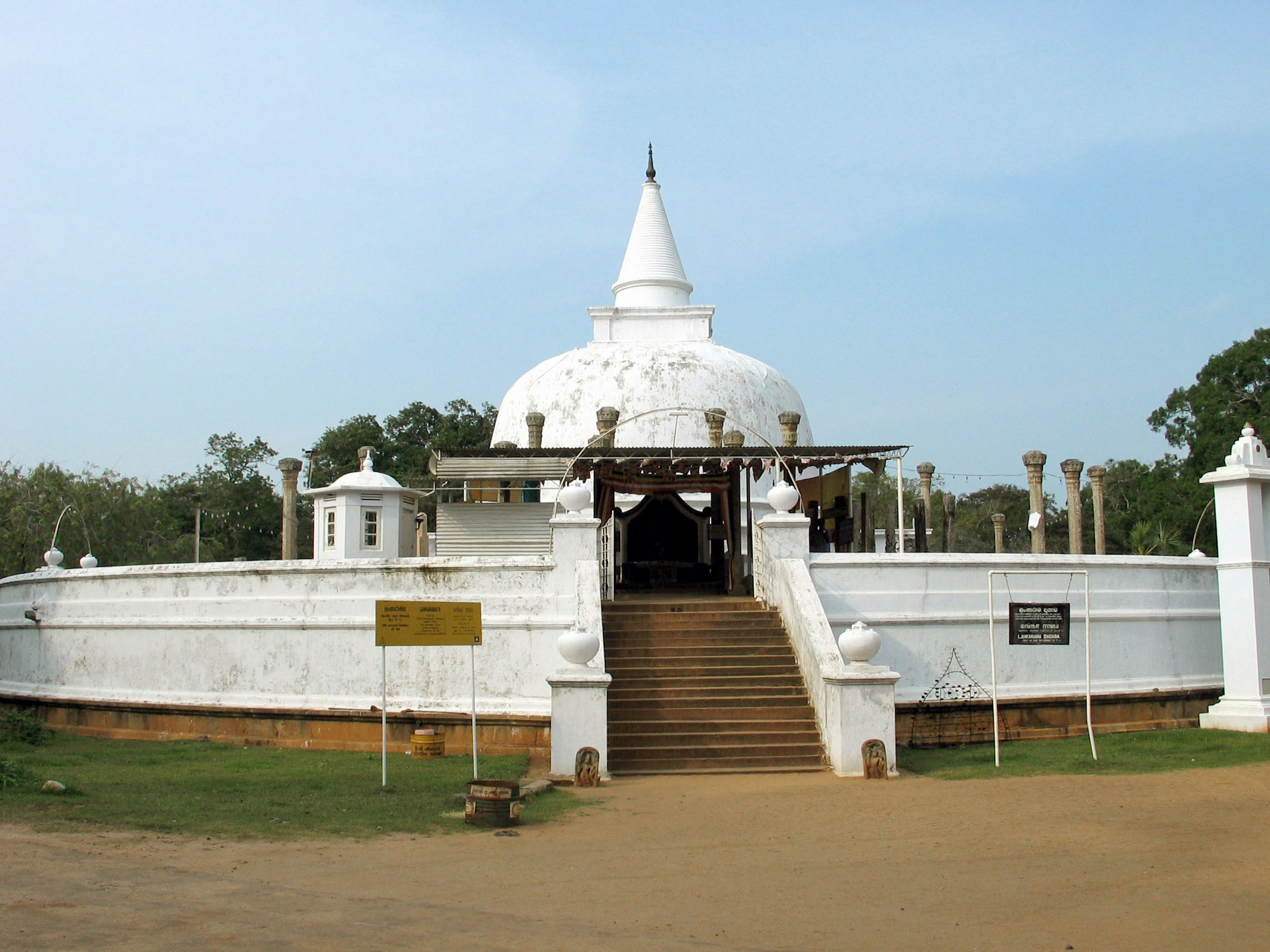 Ngoại thất của một ngôi chùa Phật giáo với stupa trắng và bậc thang