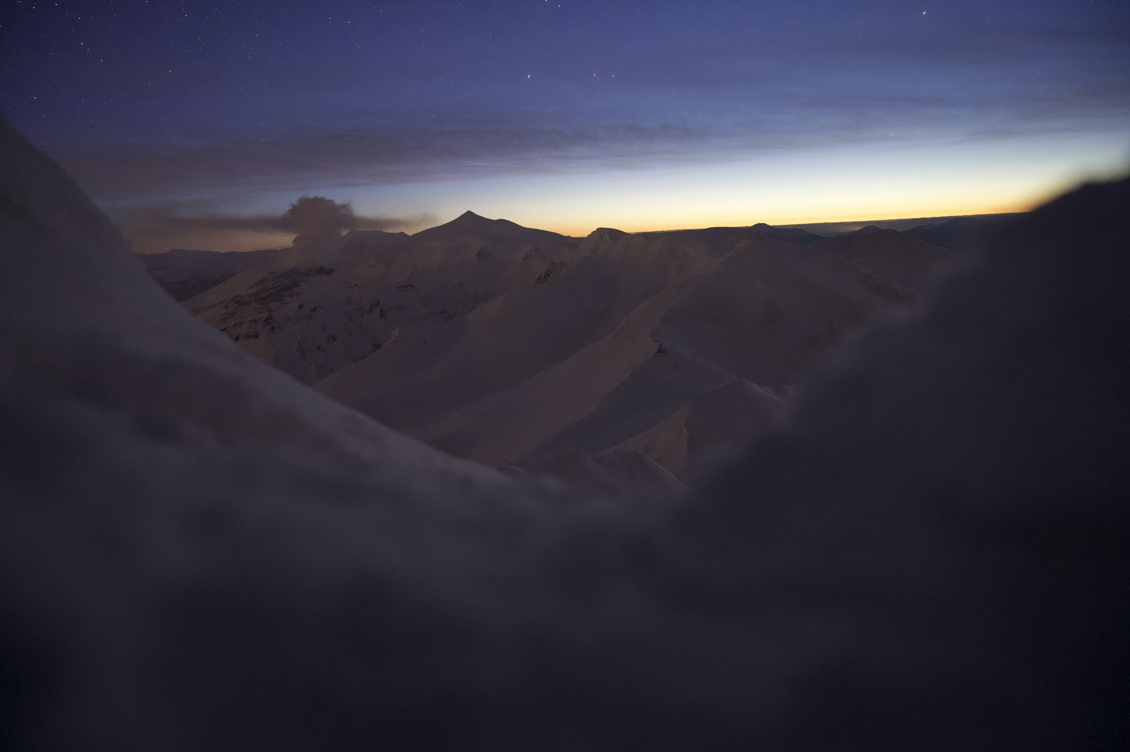 Dunkle Berge unter einem Dämmerungshimmel