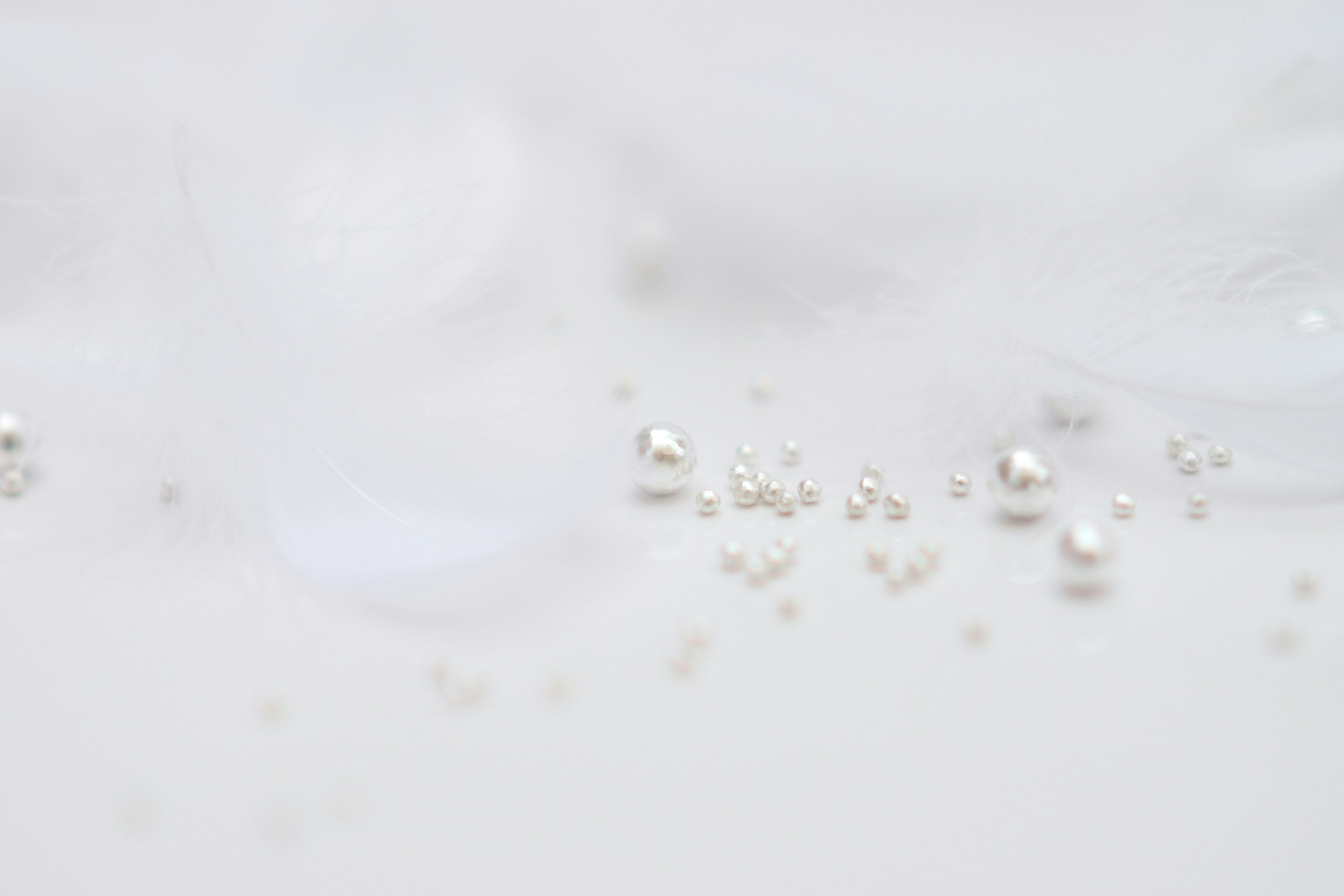 Small pearl-like objects scattered on a white background