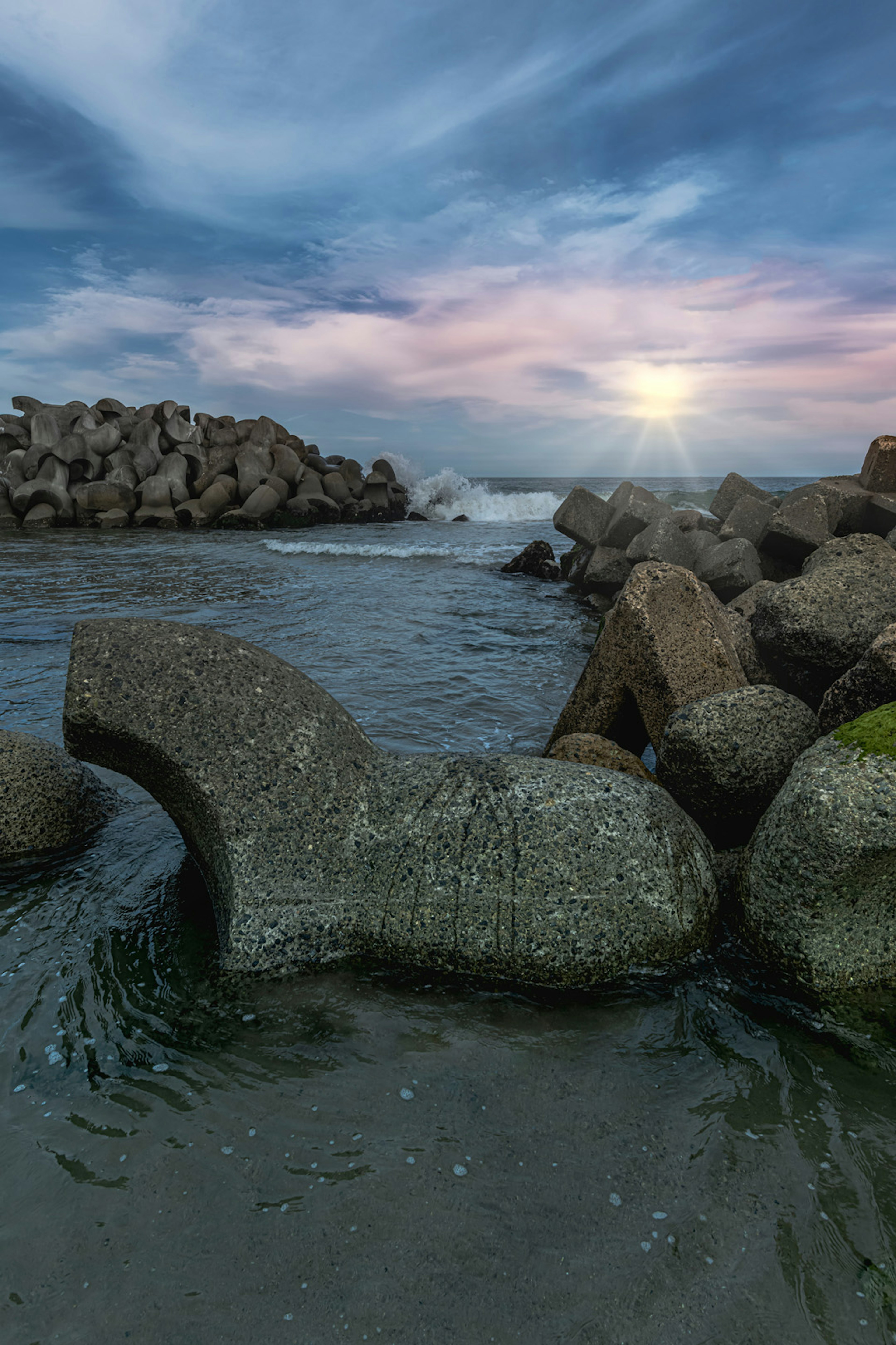 Rochers côtiers avec des vagues et un beau ciel au coucher du soleil