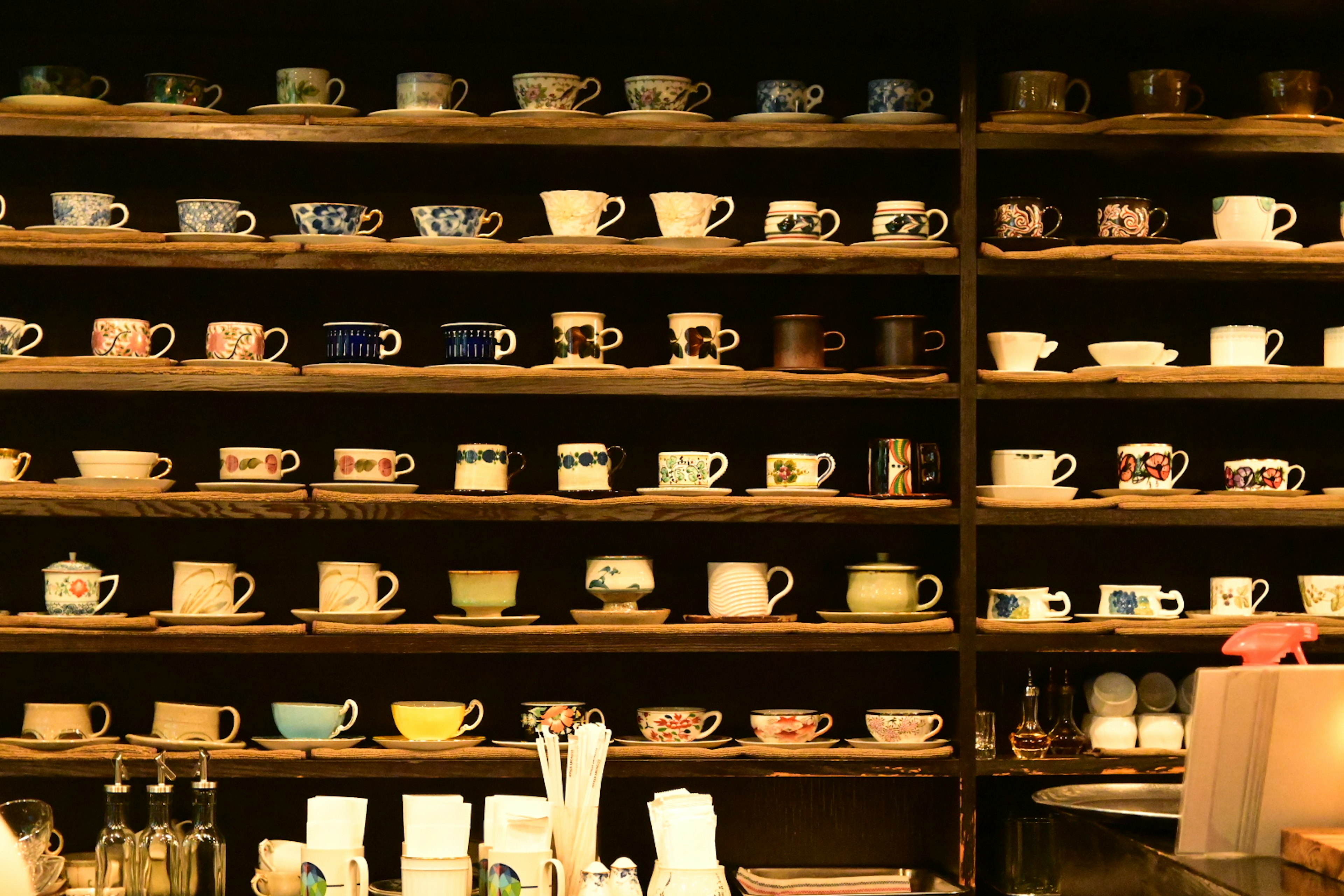 A display of colorful cups arranged on wooden shelves