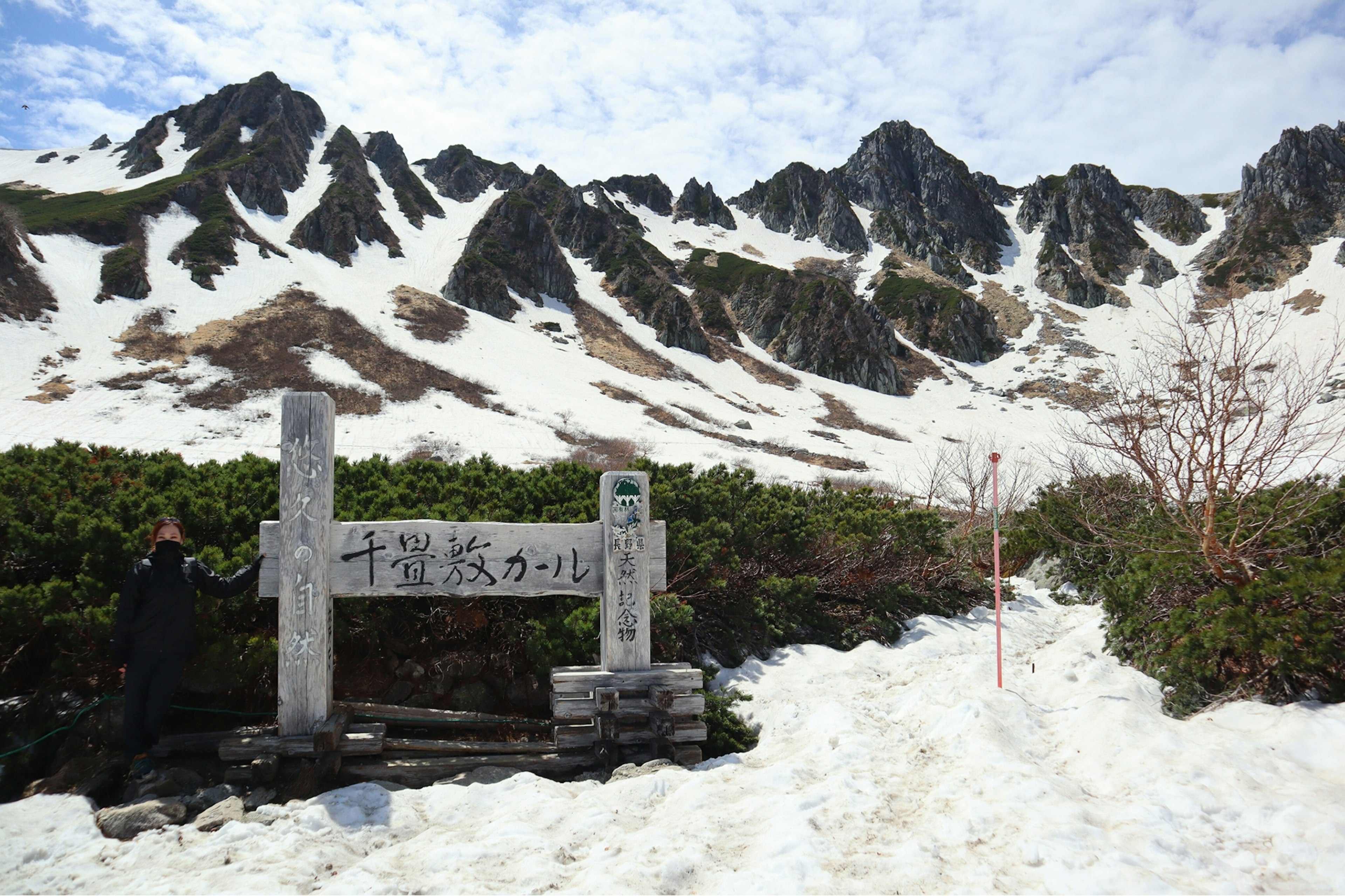 Vista escénica de montañas cubiertas de nieve con un letrero