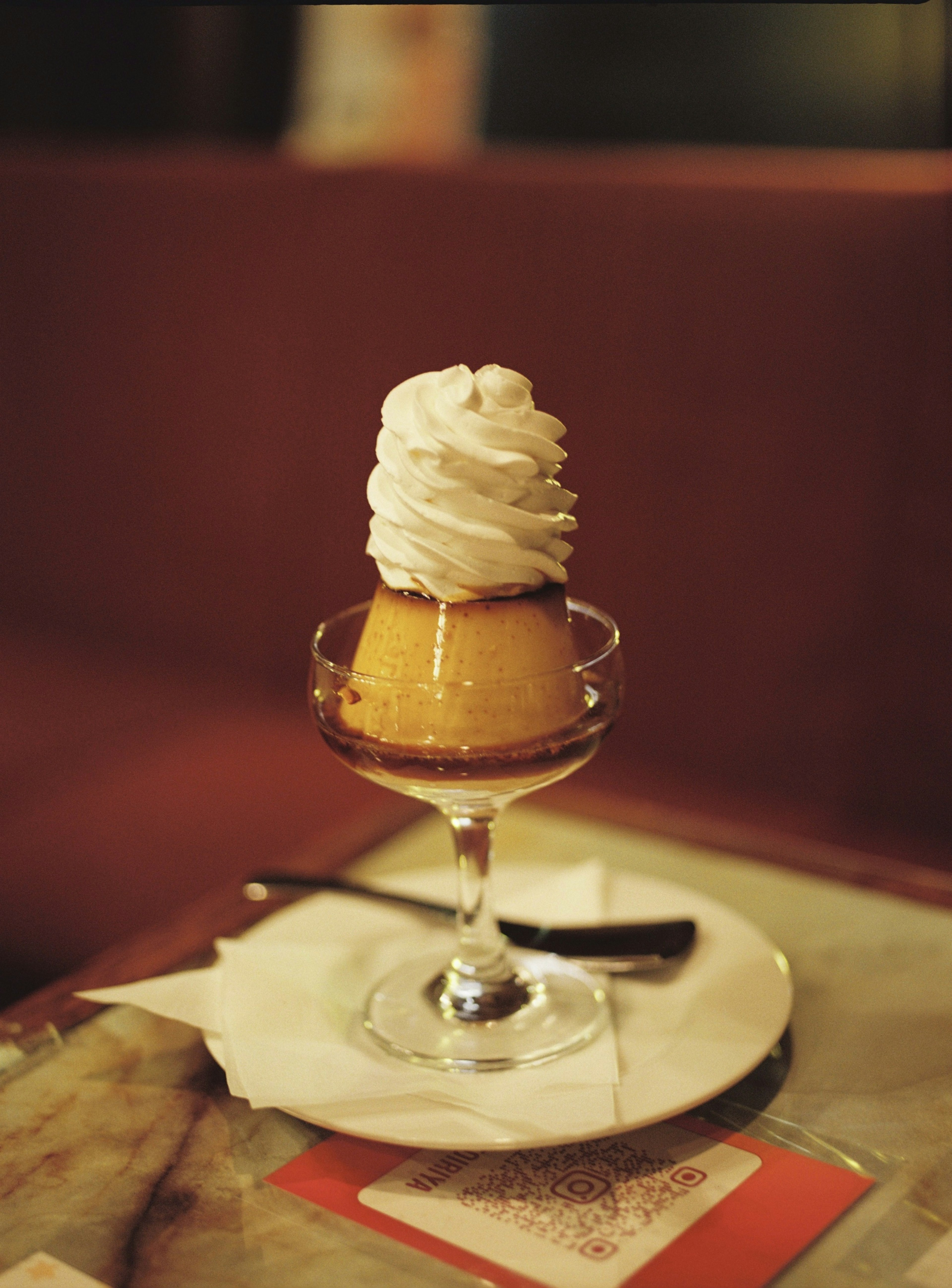 Pudding garni de crème servi dans un plat en verre