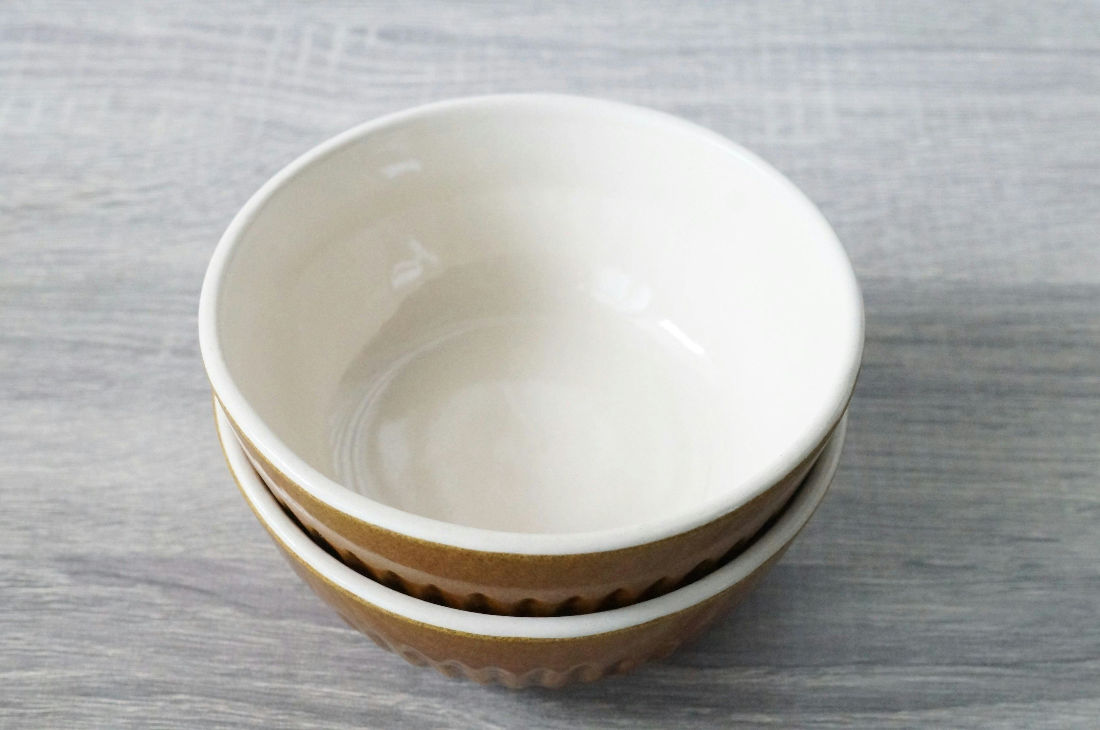 Stacked bowls with white interior and brown exterior