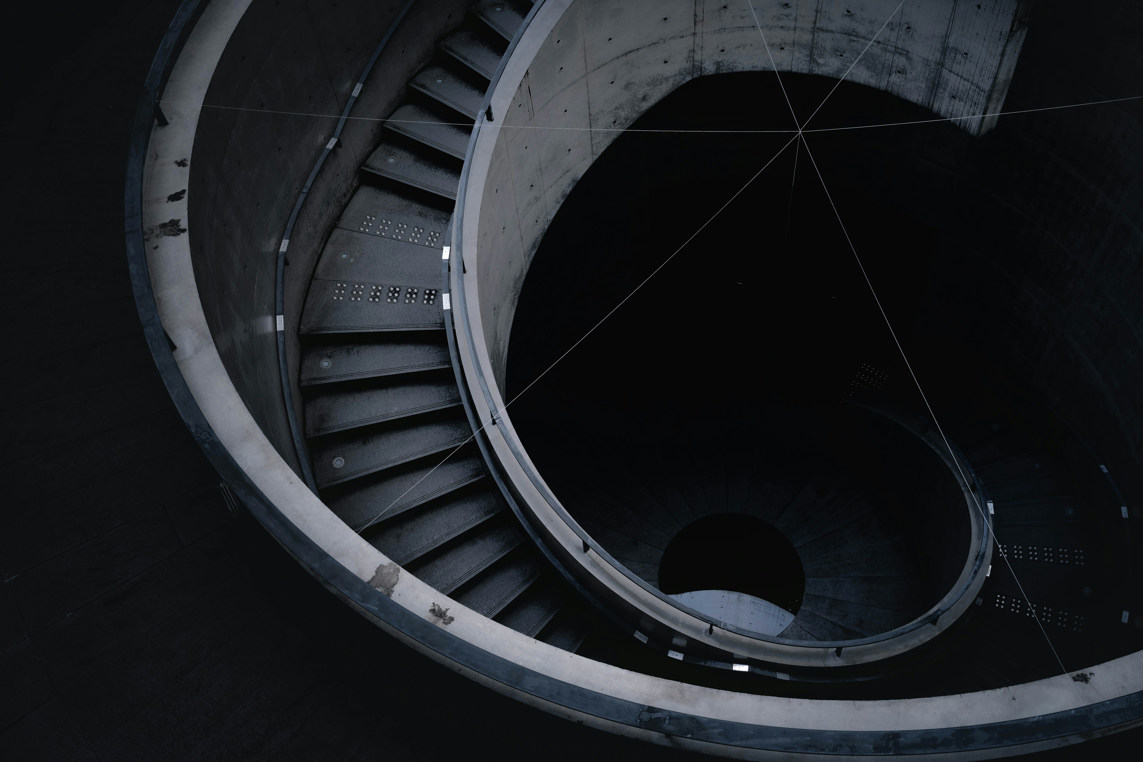 Vista aérea de una escalera circular de concreto en un espacio oscuro