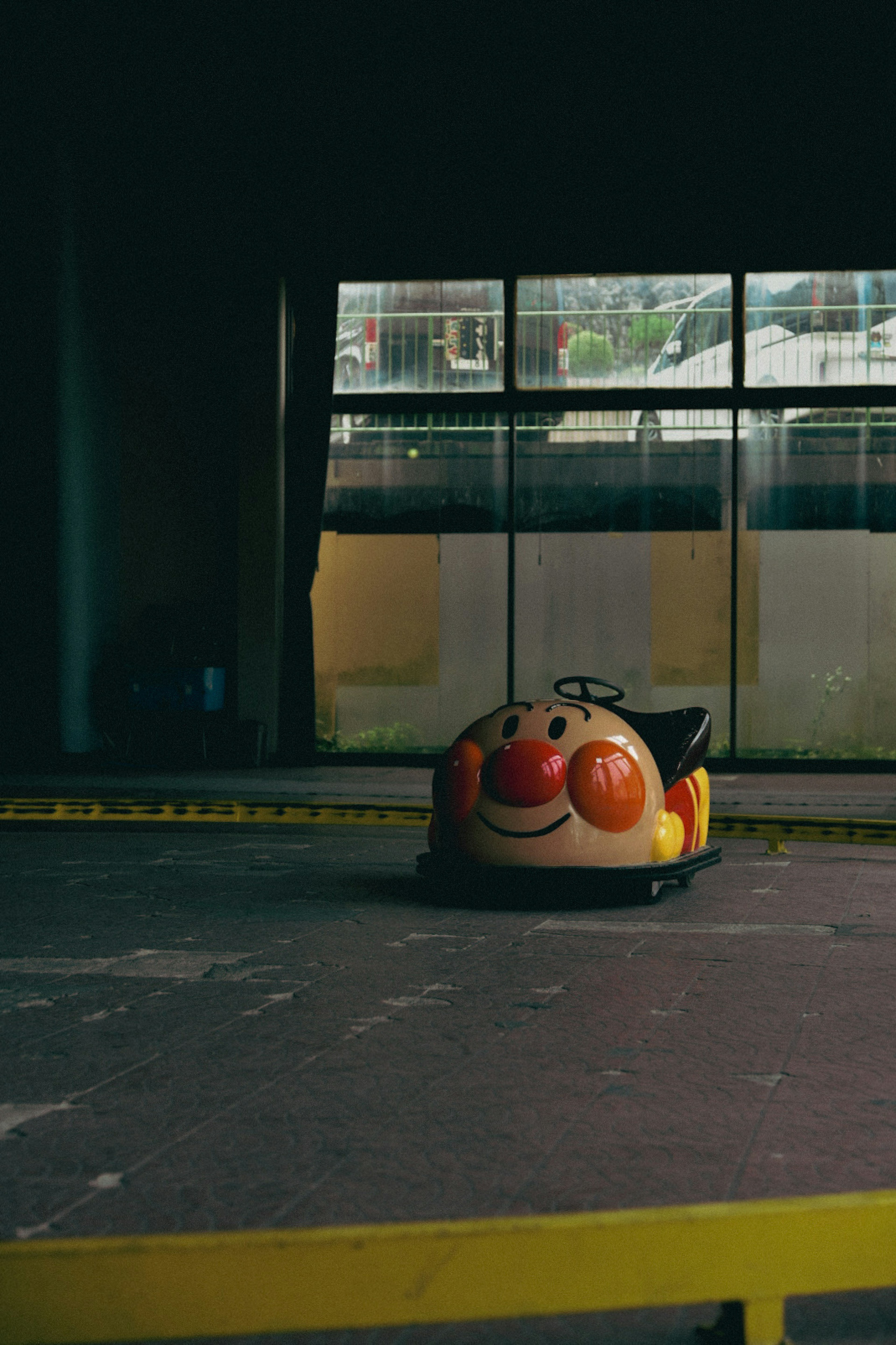 Bumper car featuring a smiling character in a dim indoor space