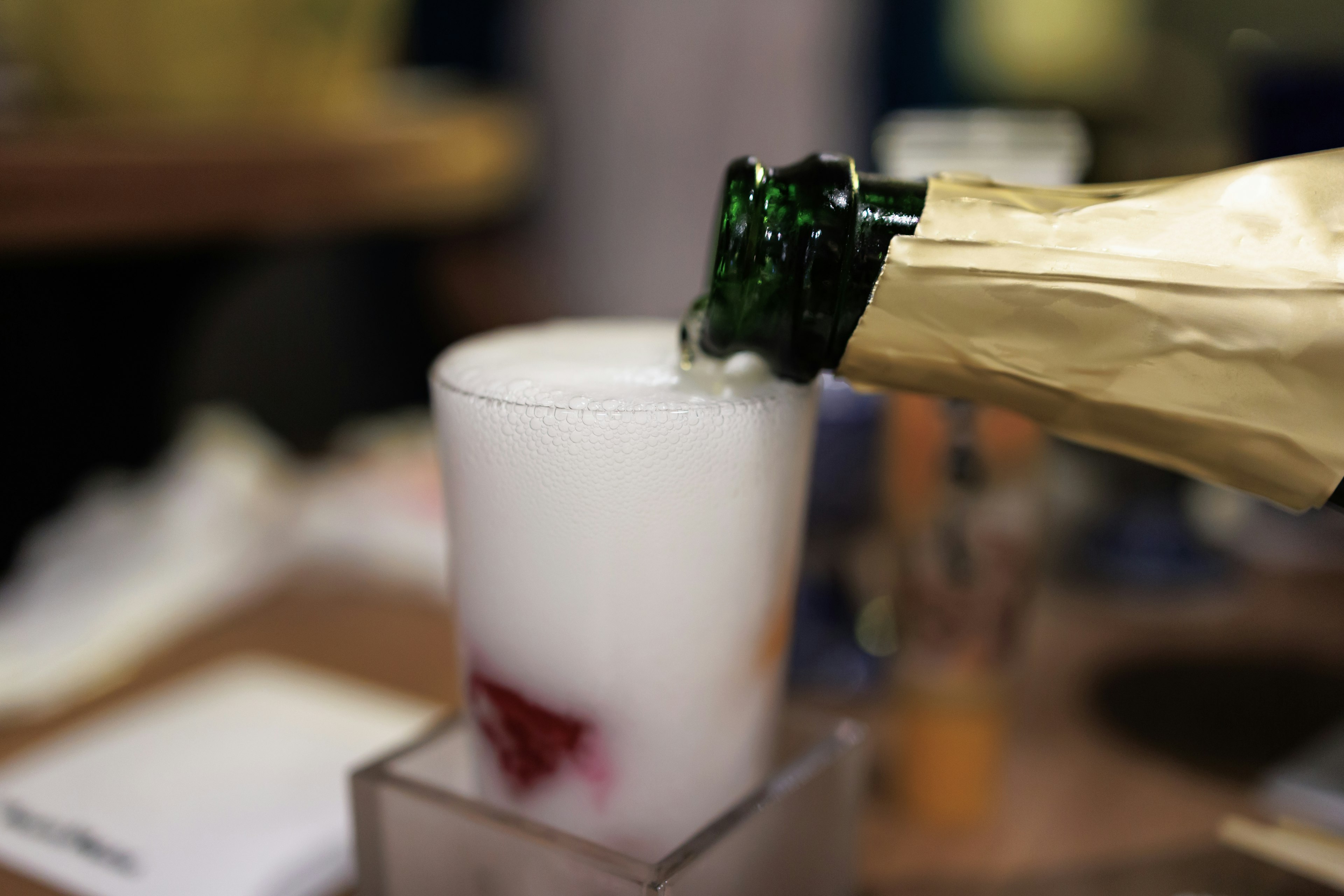 Champagne being poured into a cocktail glass with bubbles