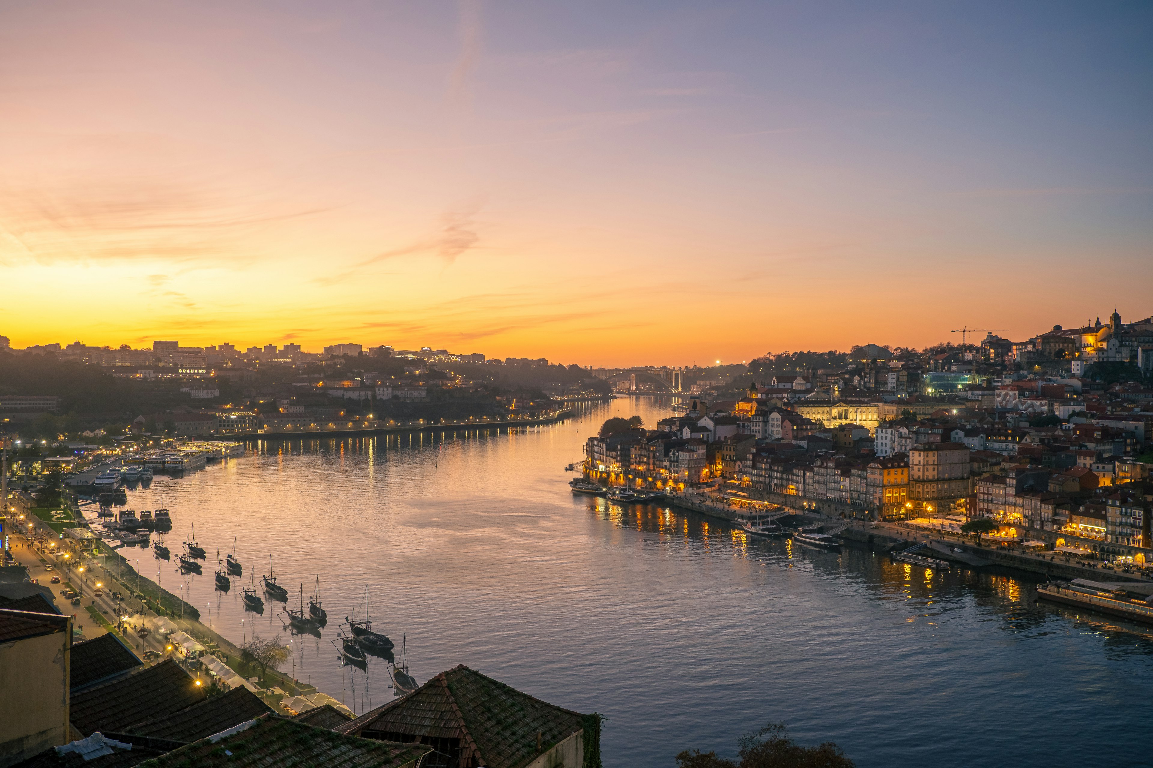 Vista escénica de Oporto al atardecer con río y edificios iluminados