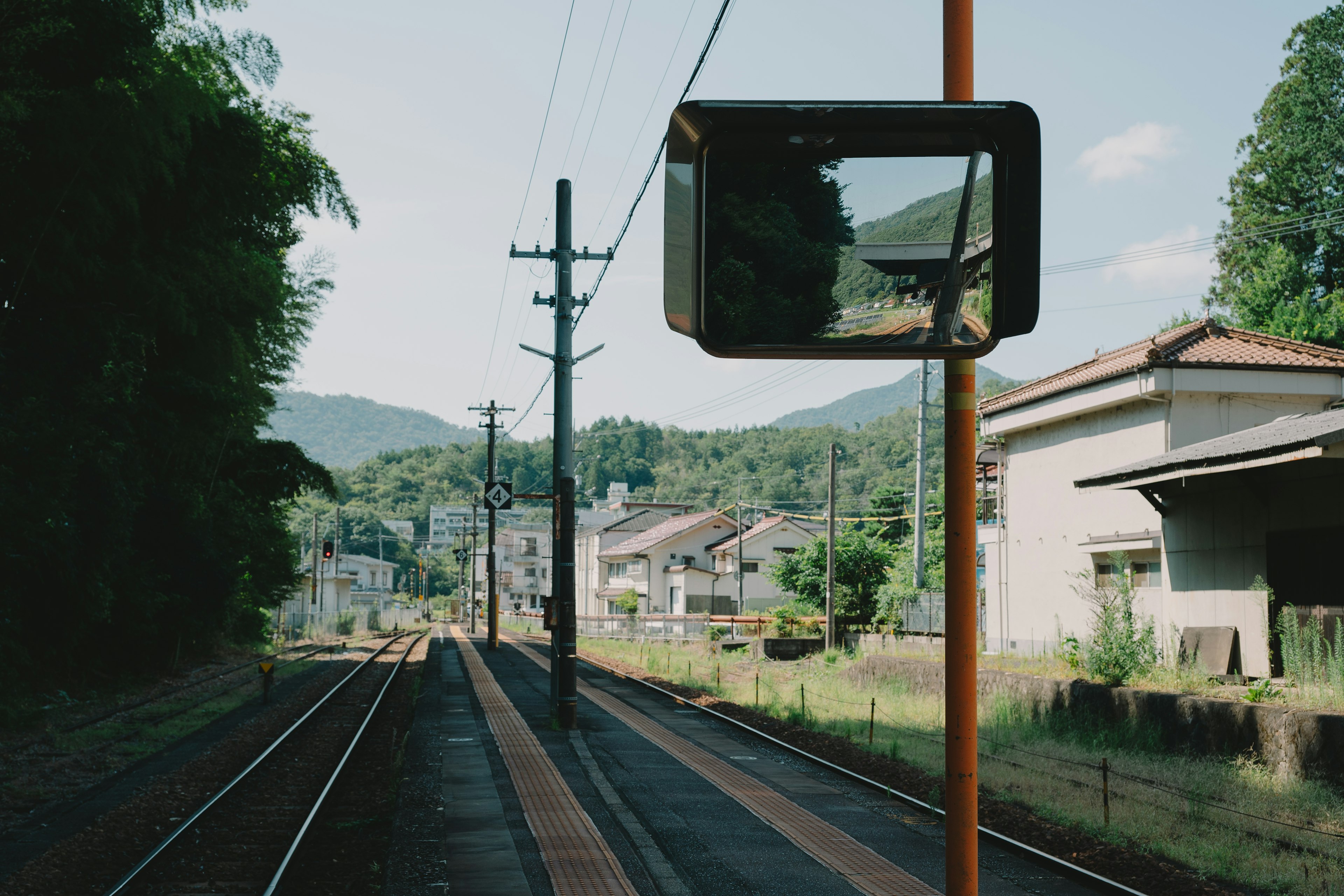 Vista di una stazione ferroviaria con uno specchio e binari