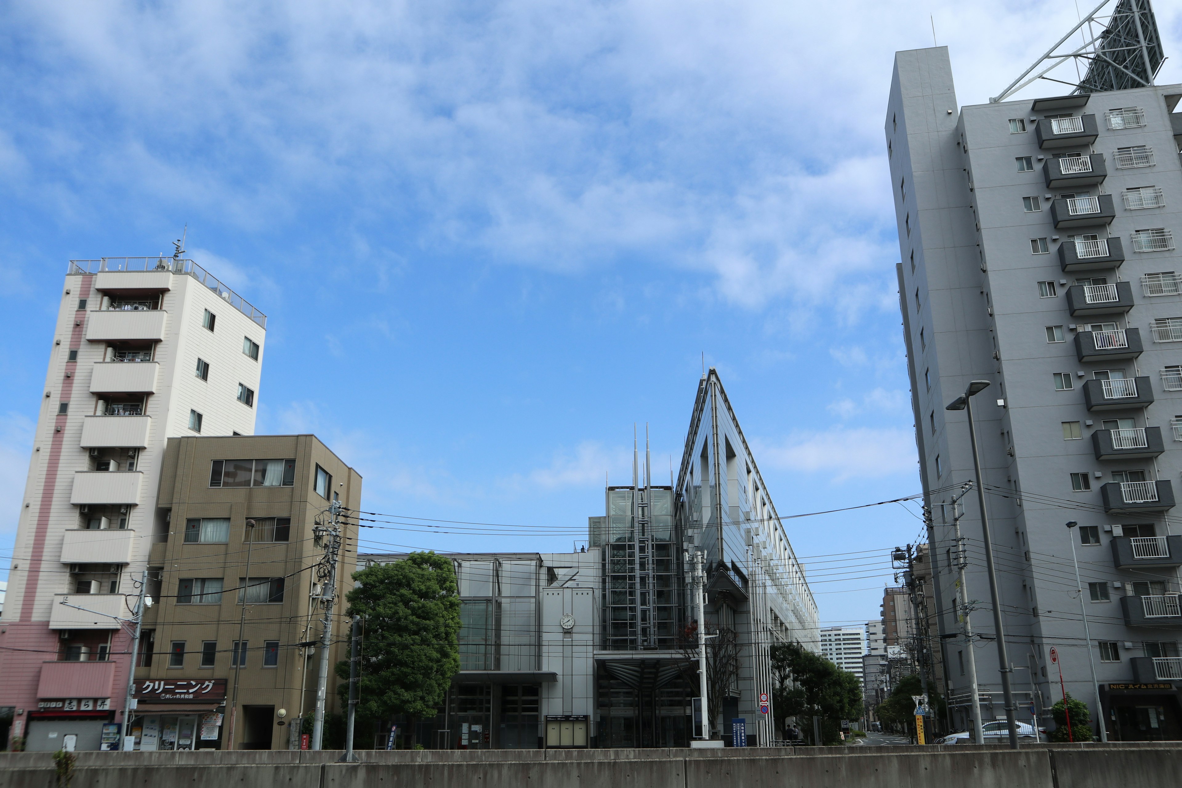 Cityscape featuring modern and older buildings under a blue sky