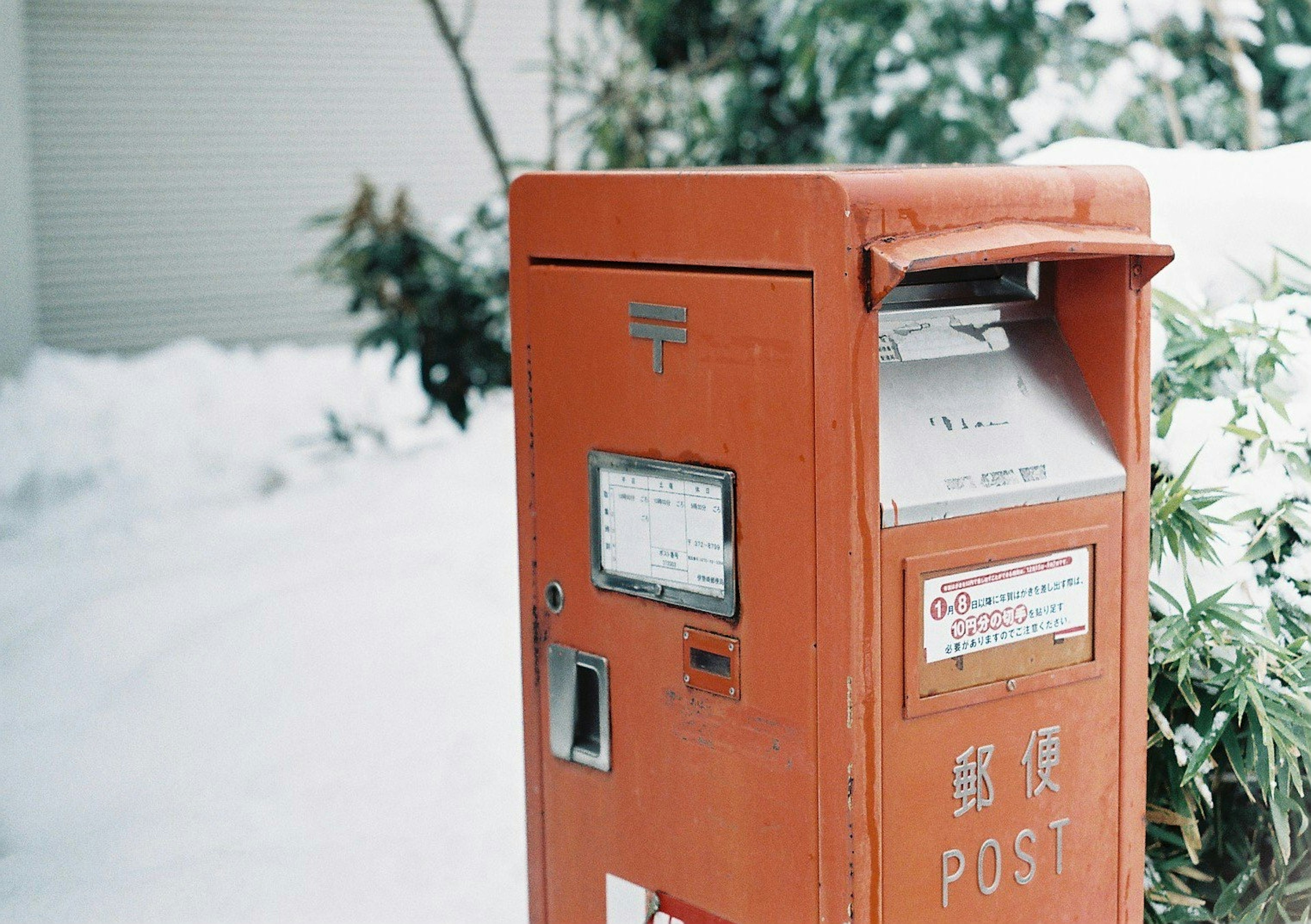 Orange post box in the snow