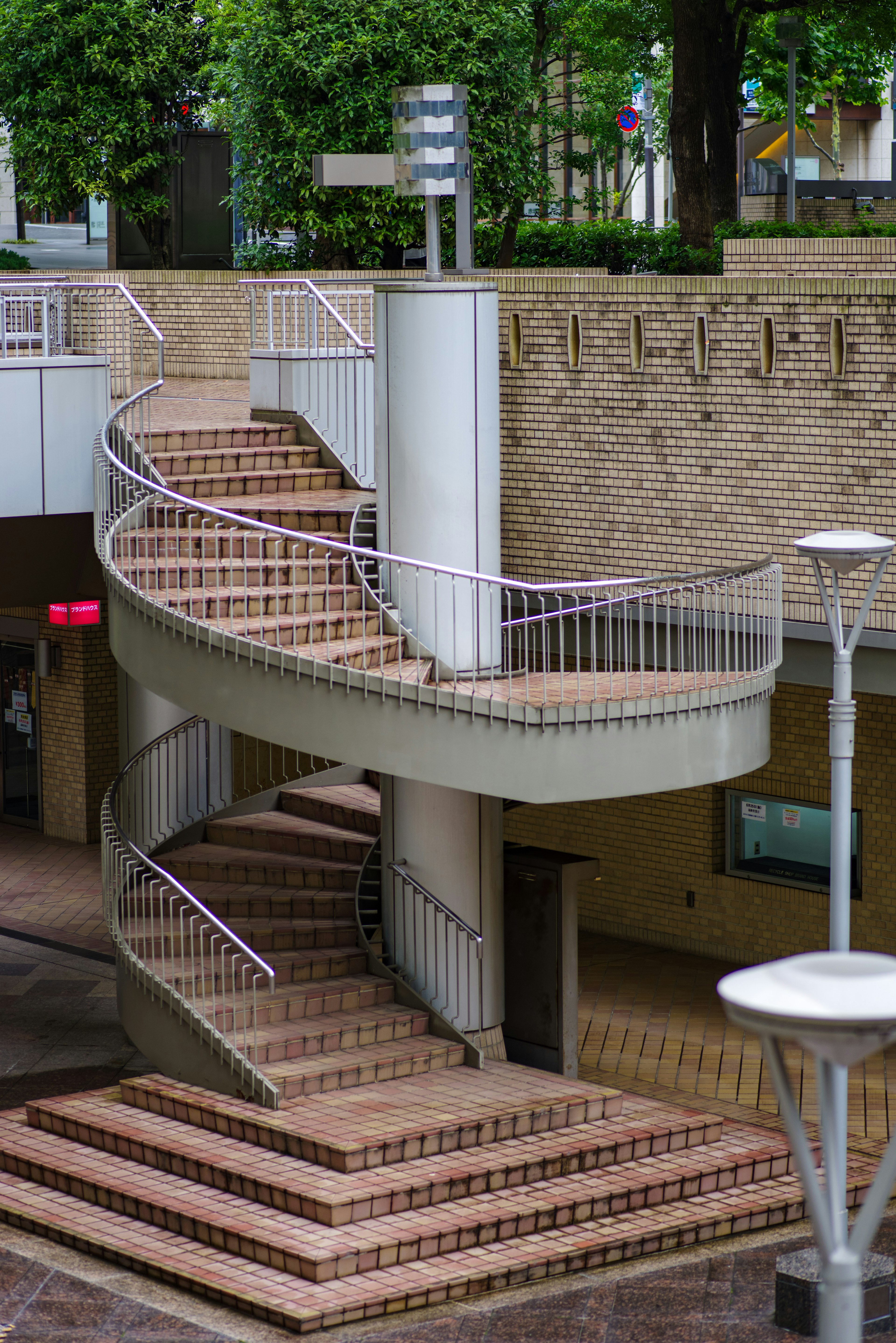 Modern building exterior featuring a spiral staircase and surrounding greenery