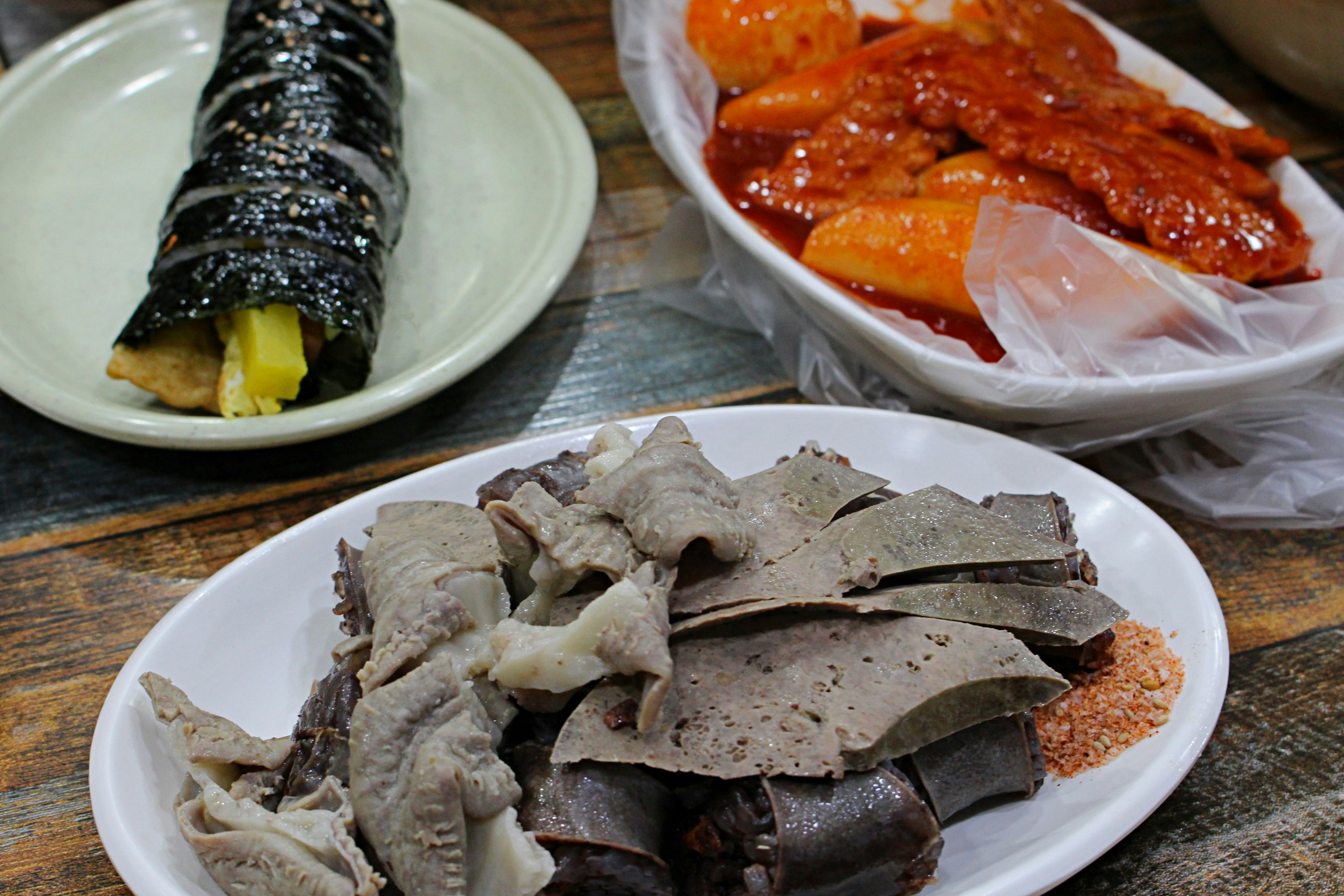 A platter of Korean dishes including gimbap and spicy fish