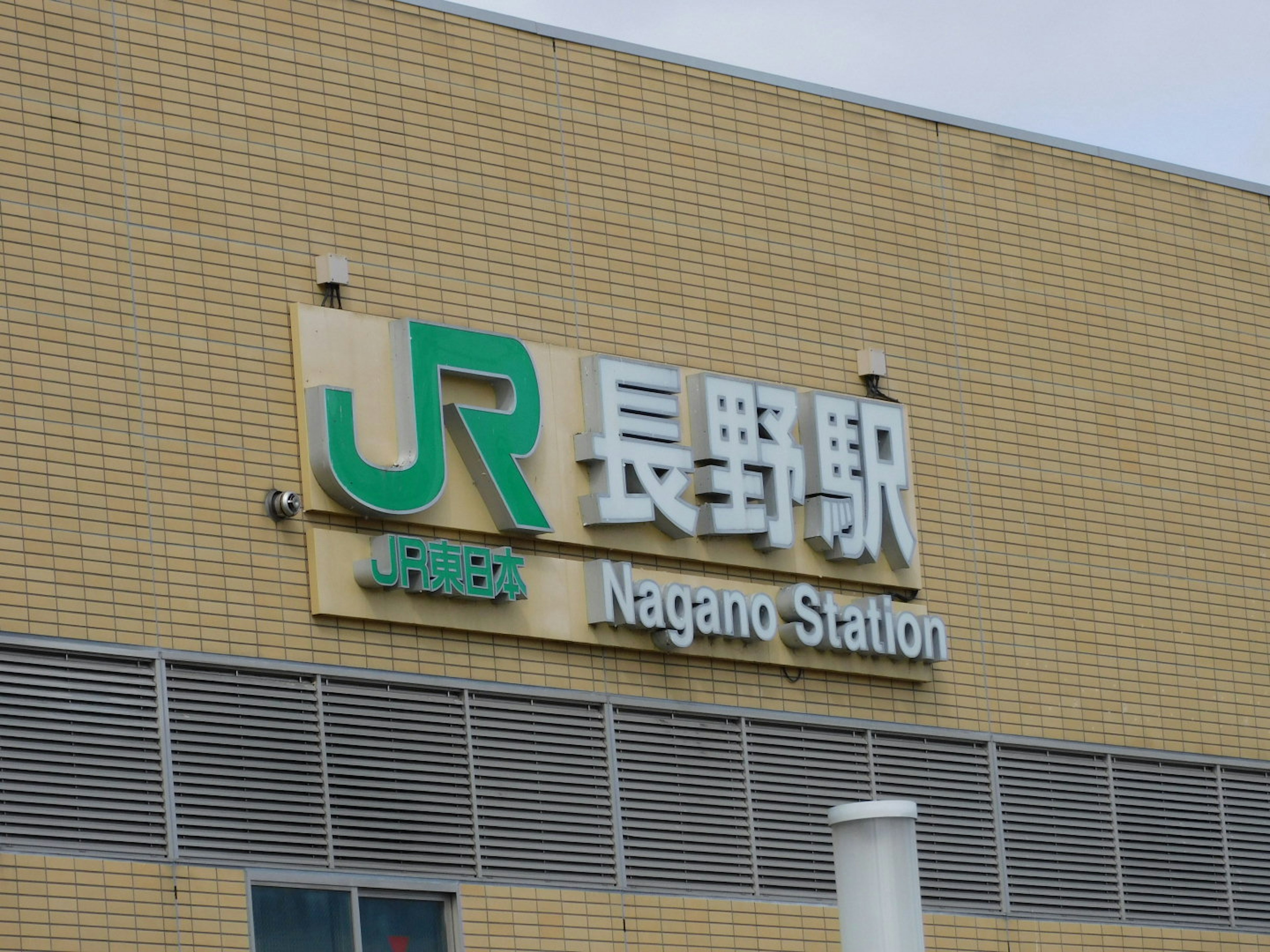 Schild des Nagano Bahnhofs sichtbar an der Außenseite des Bahnhofs