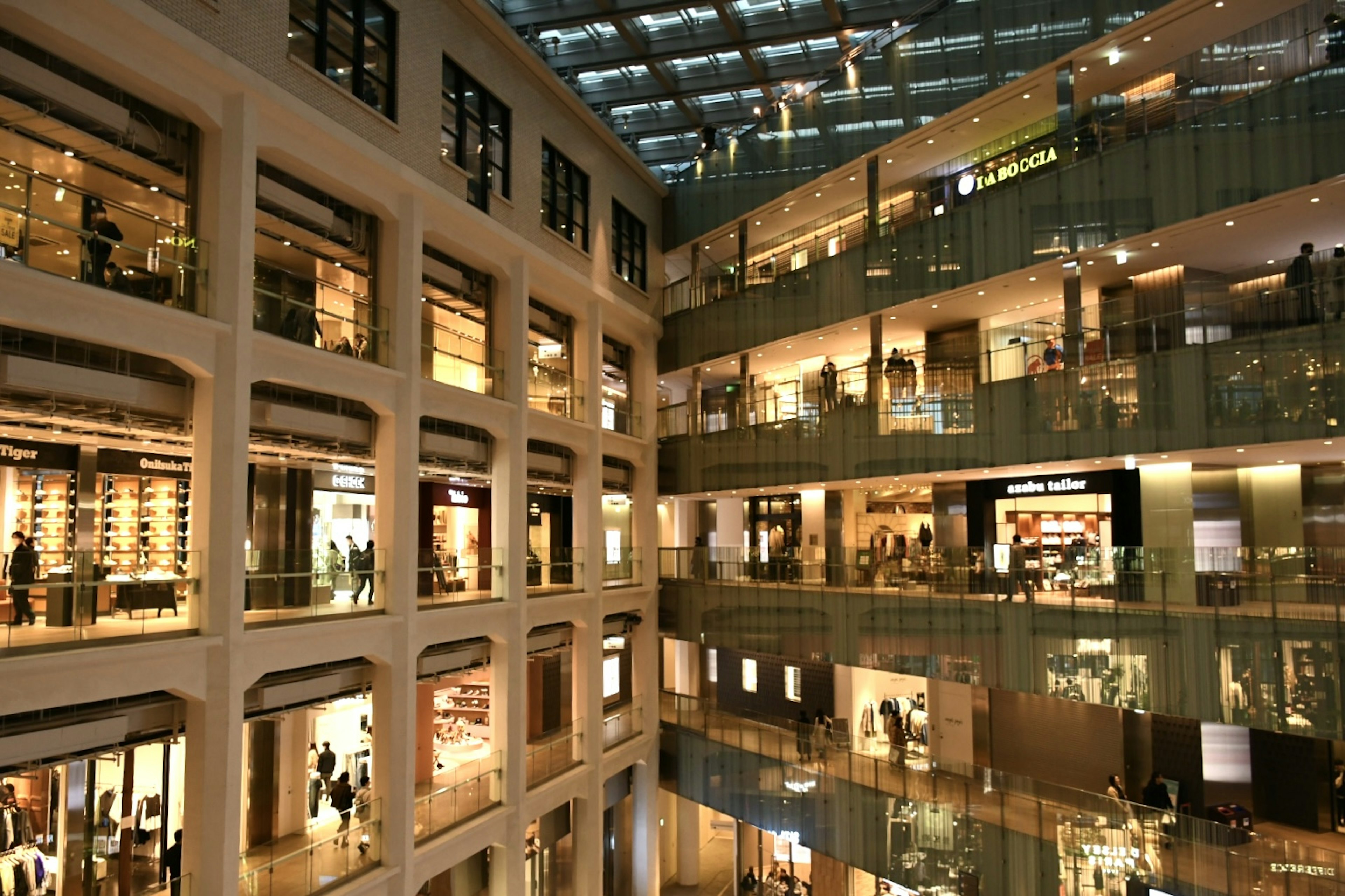 Vue intérieure d'un centre commercial moderne avec plusieurs étages et balcons en verre