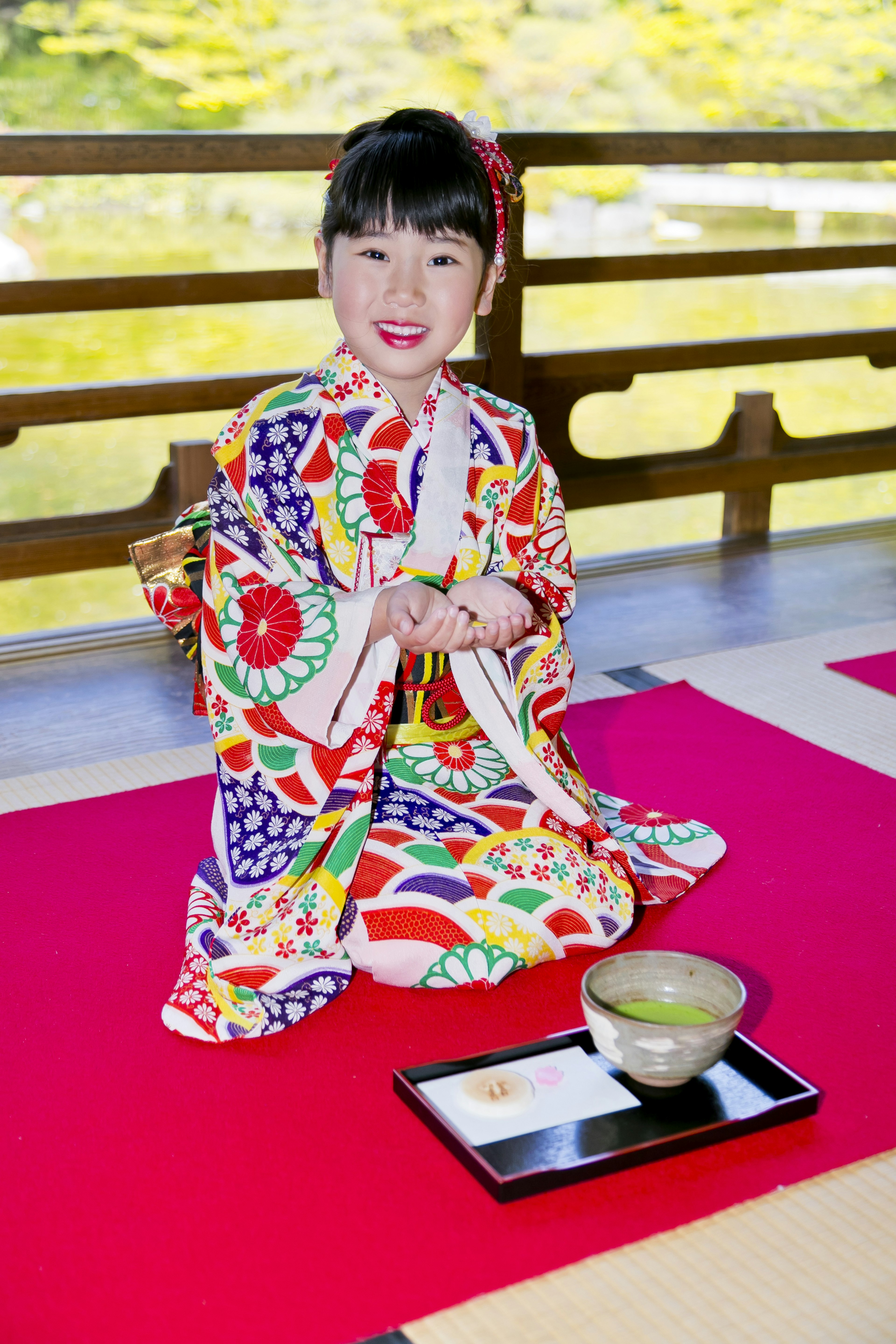 Una niña en un kimono colorido preparándose para una ceremonia del té