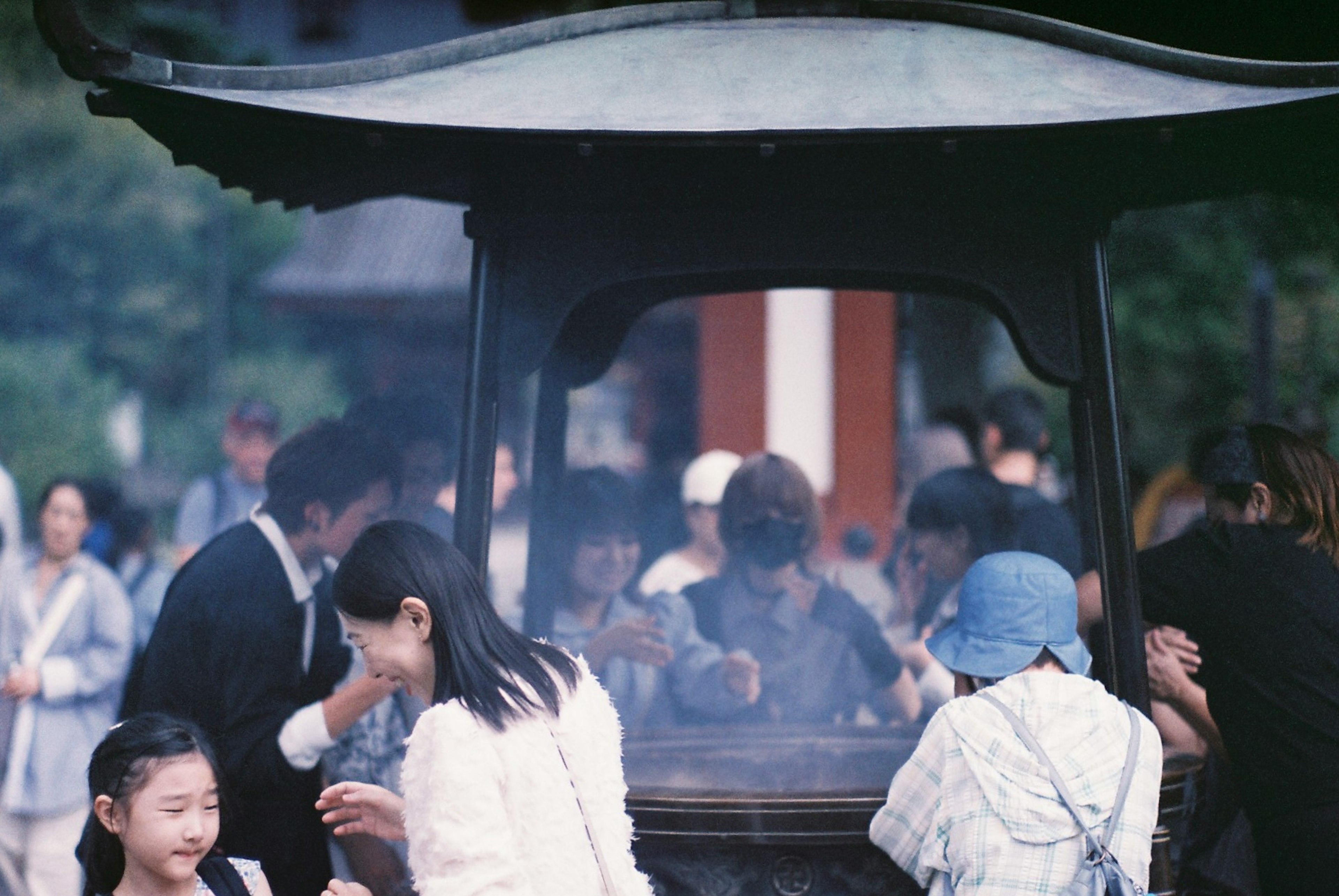 煙の中でお祈りをする人々と子供たちがいる風景