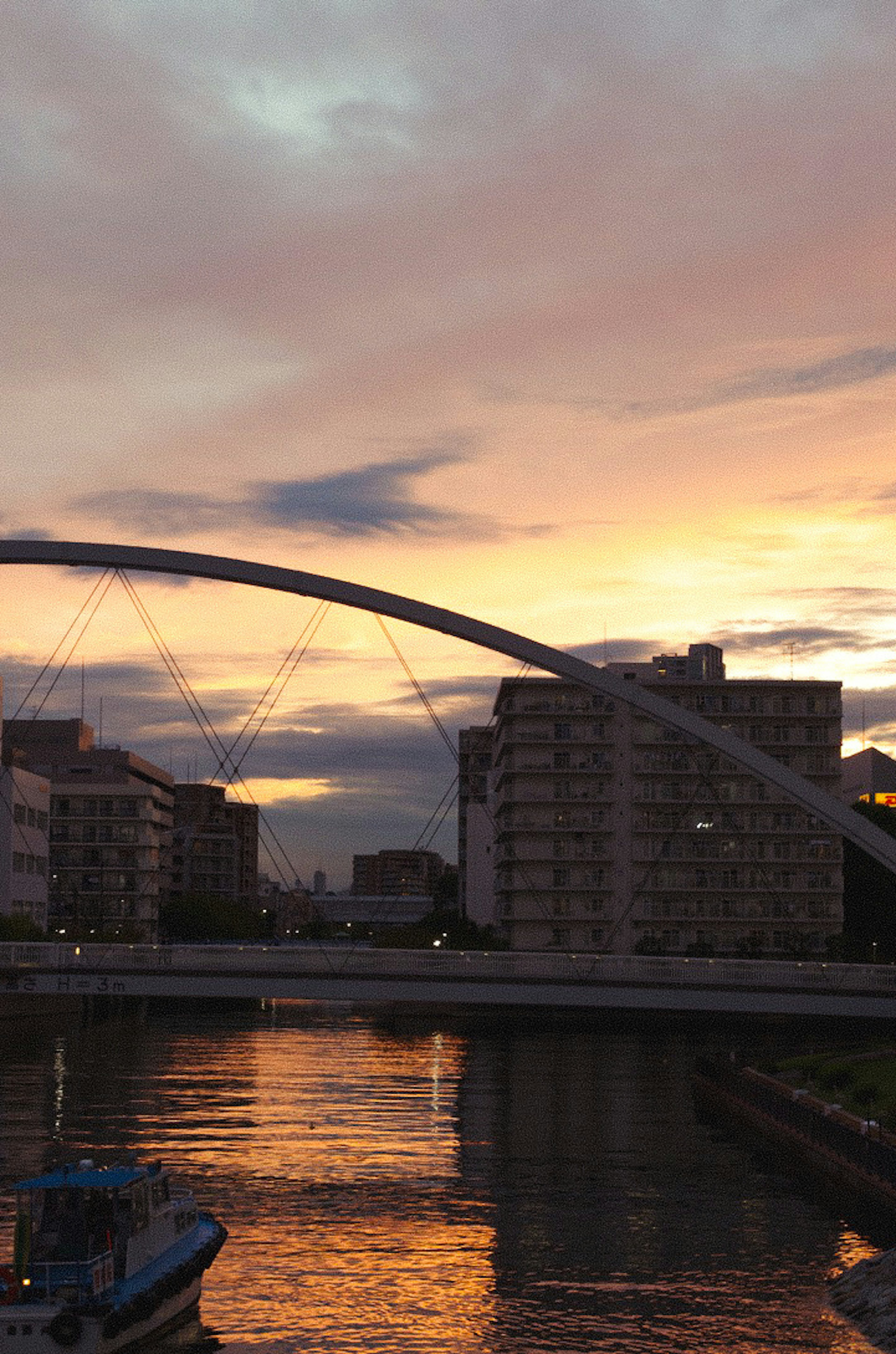 Vue panoramique d'un pont en arc sur une rivière au coucher du soleil