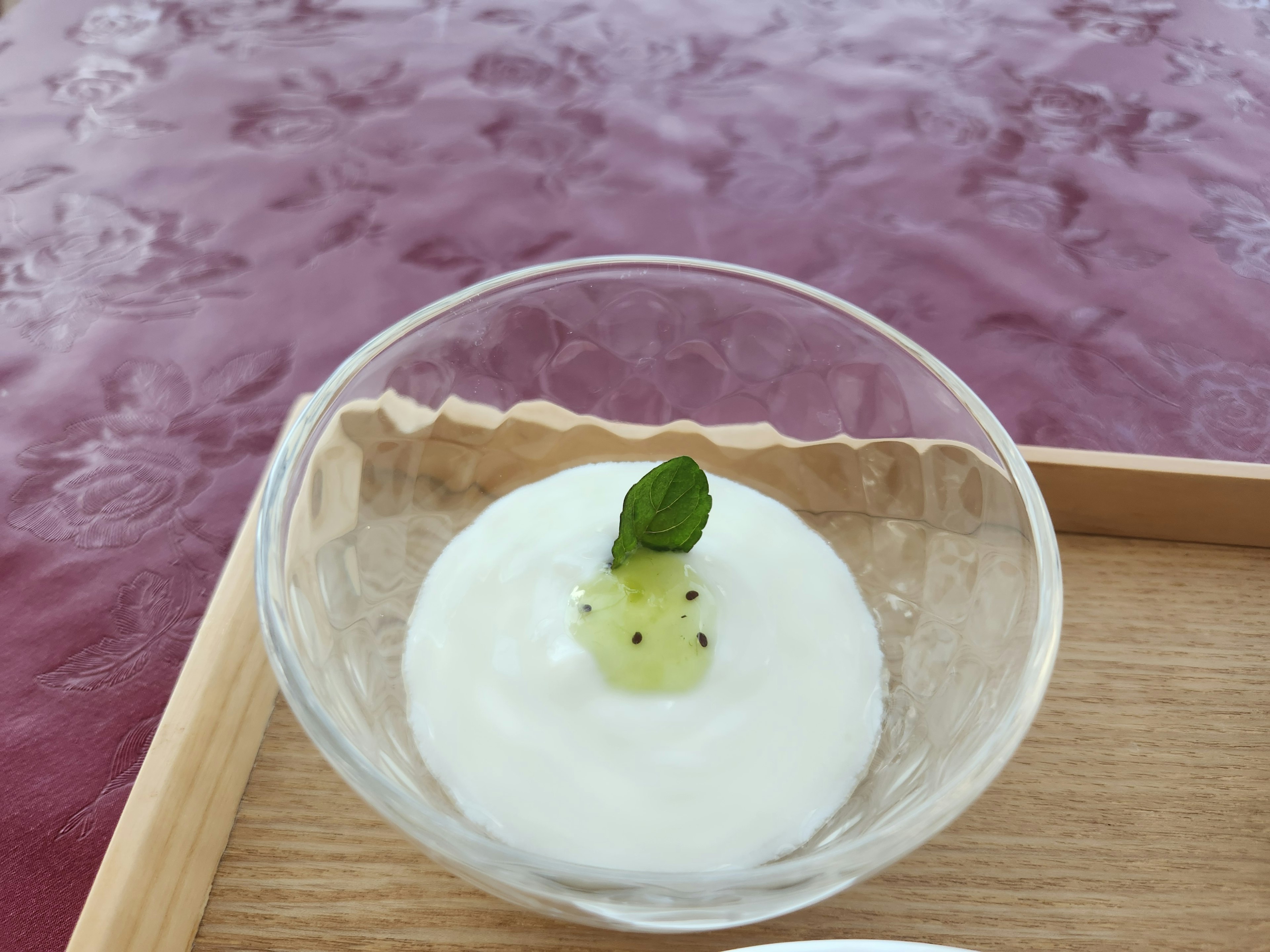 Dessert crémeux dans un bol en verre garni d'une feuille de menthe