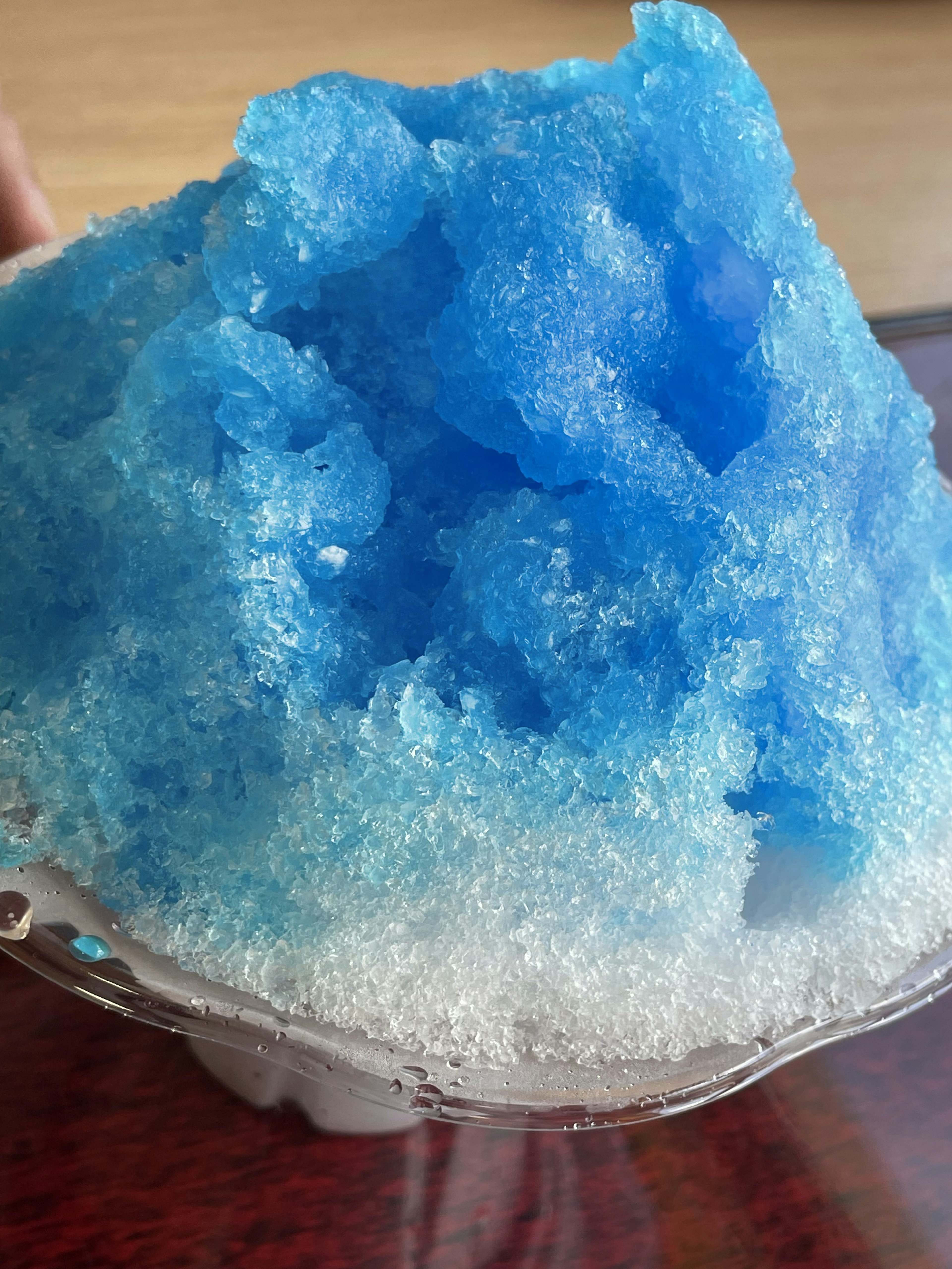 A mountain of blue shaved ice sitting atop white ice