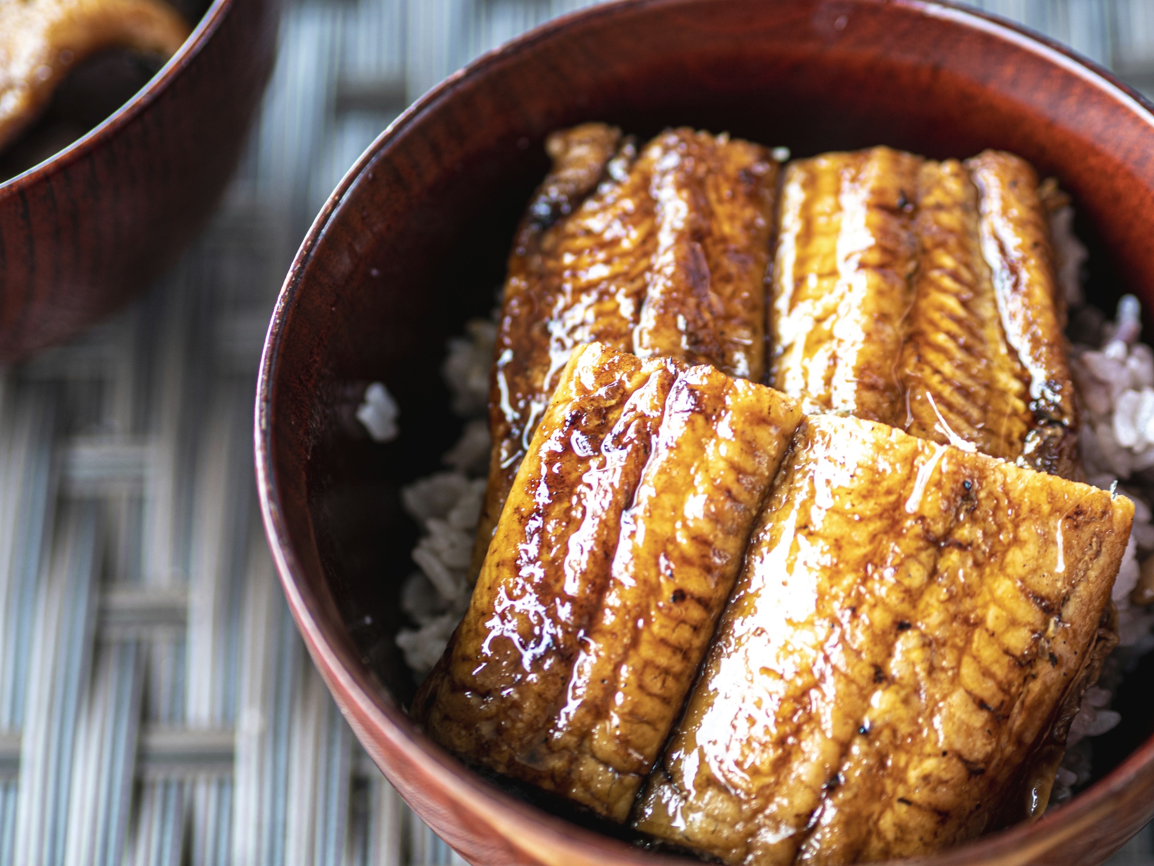 Deliciously arranged grilled eel on rice in a wooden bowl