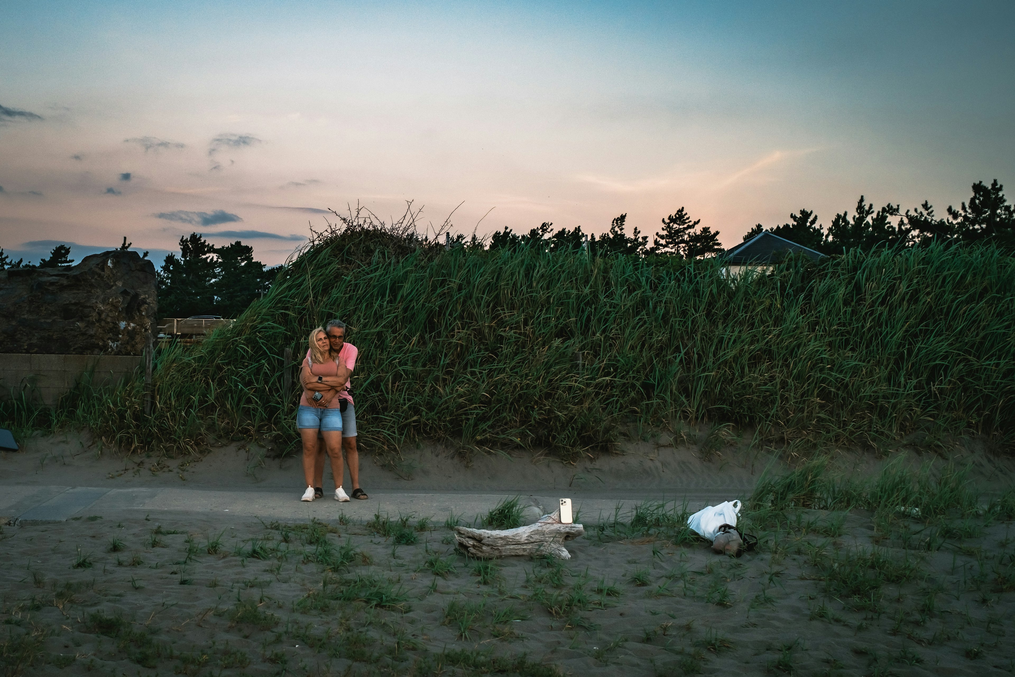 Couple standing on the beach during twilight surrounded by nature