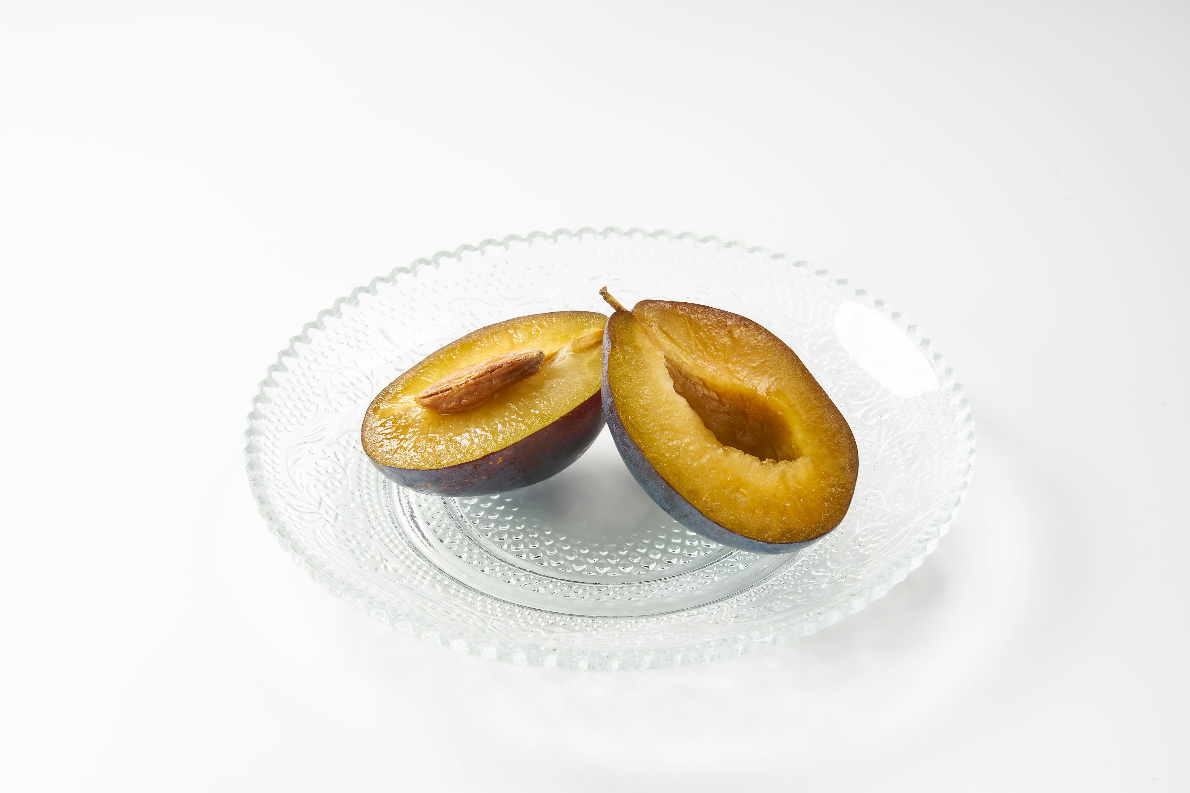 Fruta en rodajas en un plato transparente con fondo blanco