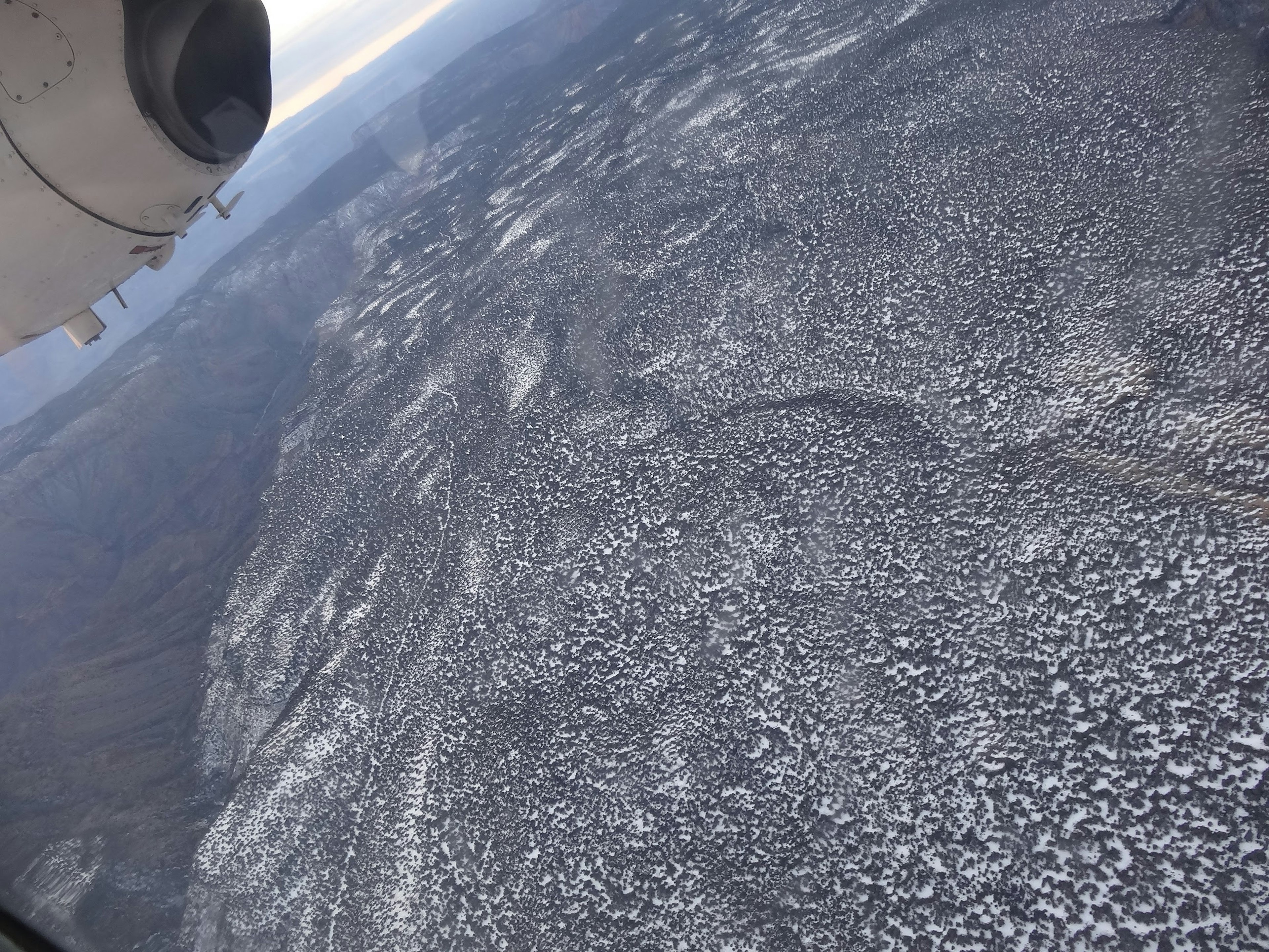 飛行機の窓から見た雪に覆われた風景と山々