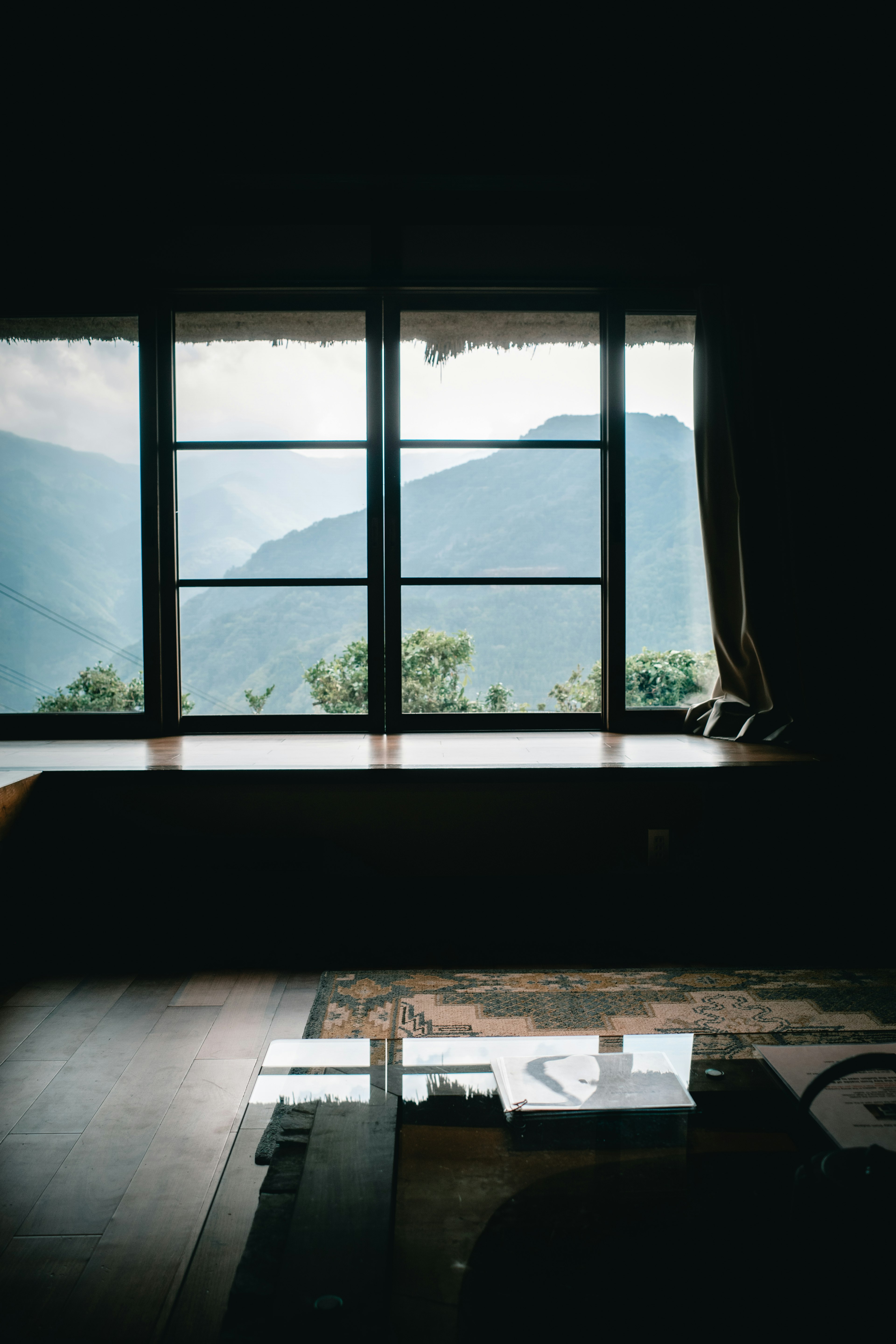 Intérieur d'une pièce avec une fenêtre donnant sur un paysage montagneux