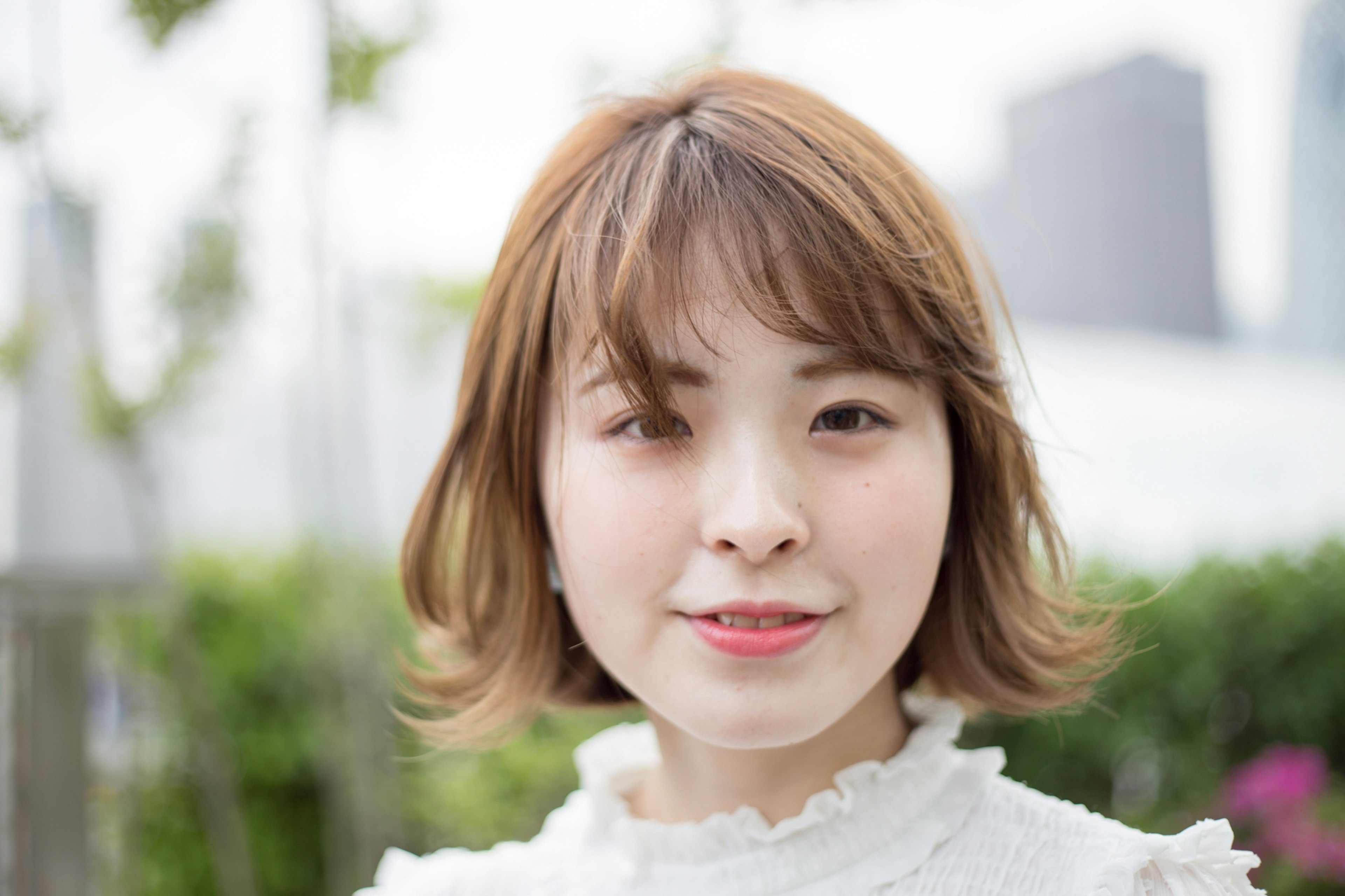 Portrait of a young woman smiling with a park background