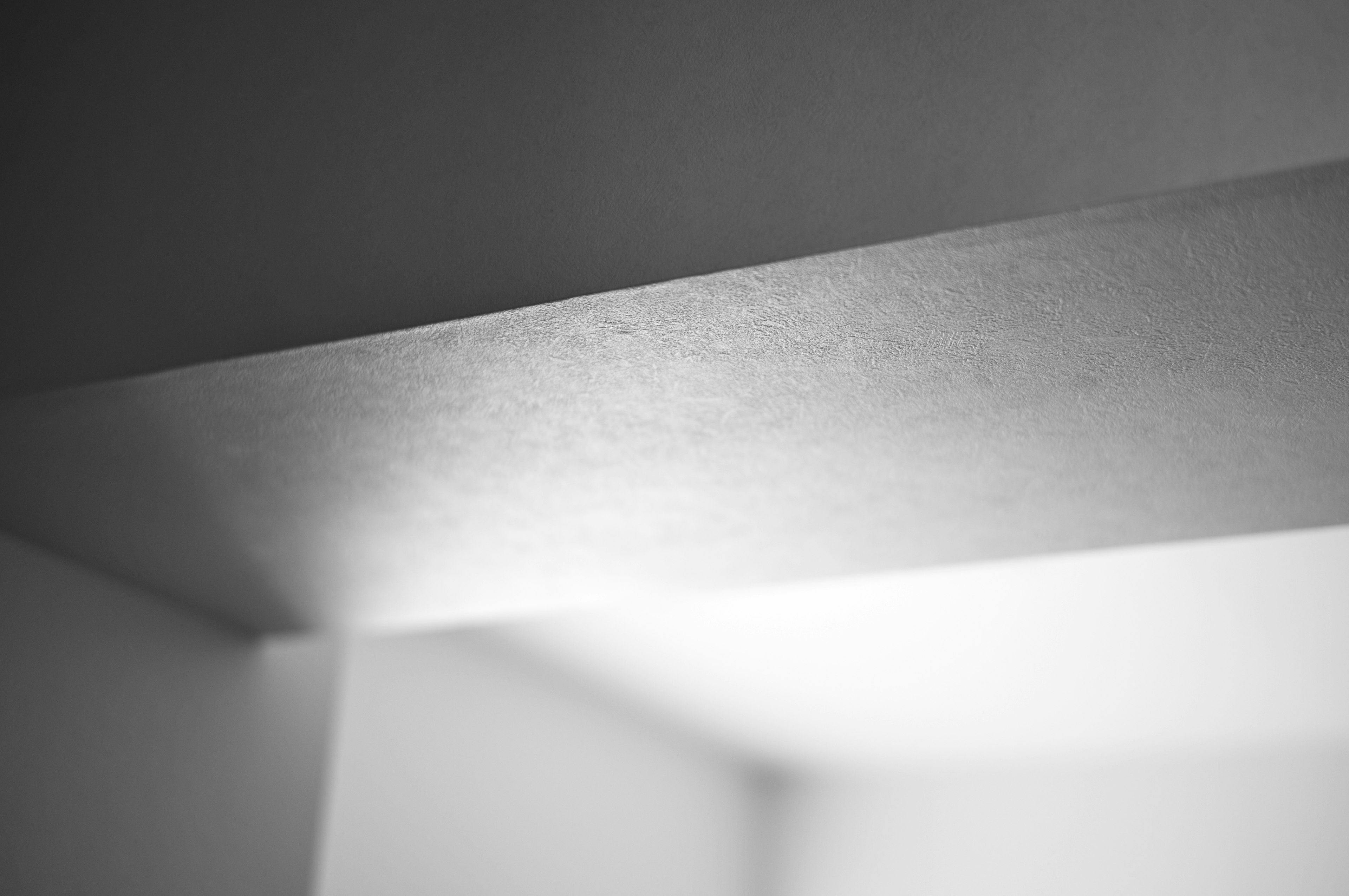 Imagen abstracta en blanco y negro de una esquina de pared con reflexión de luz