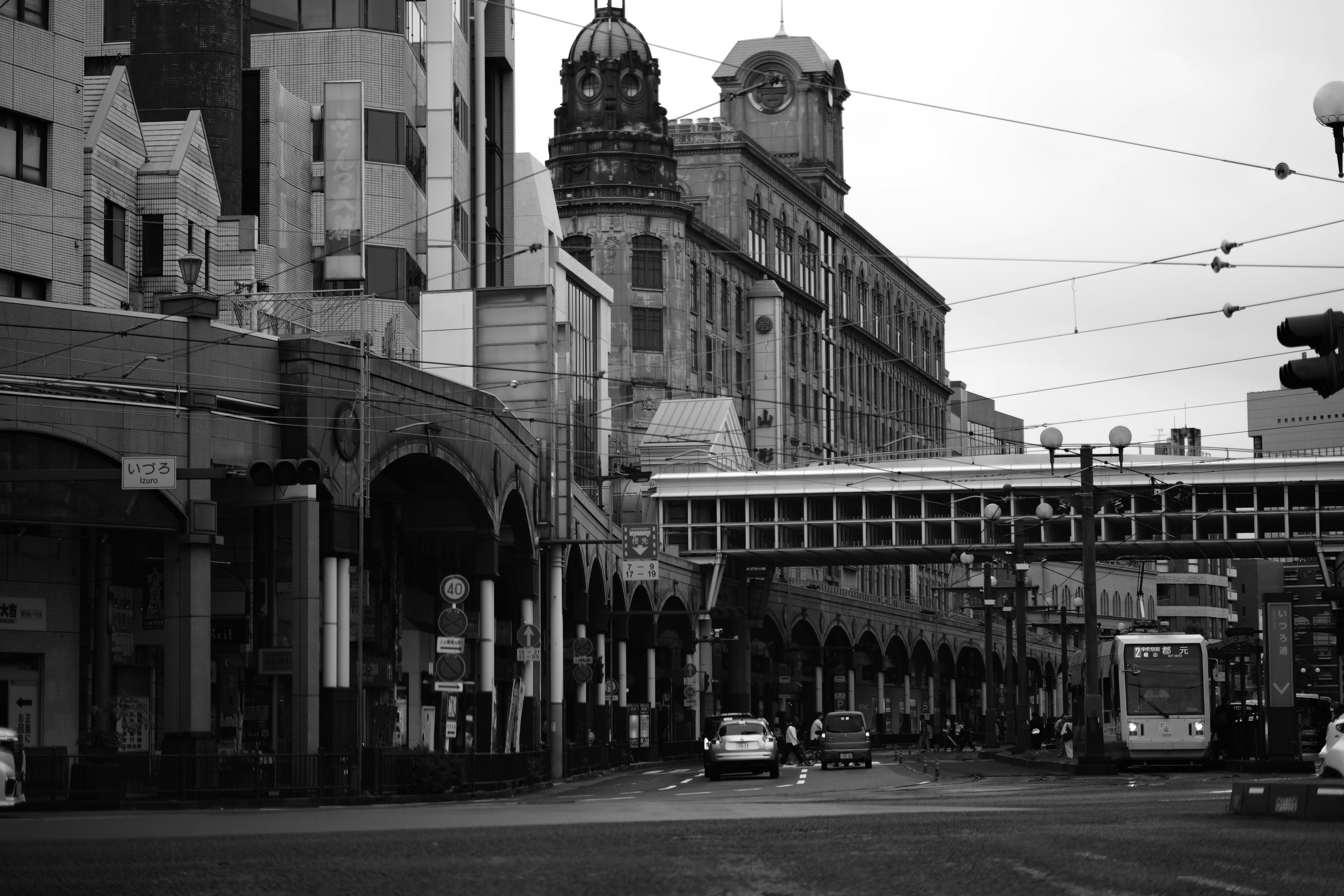 Black and white cityscape featuring old buildings and a tram