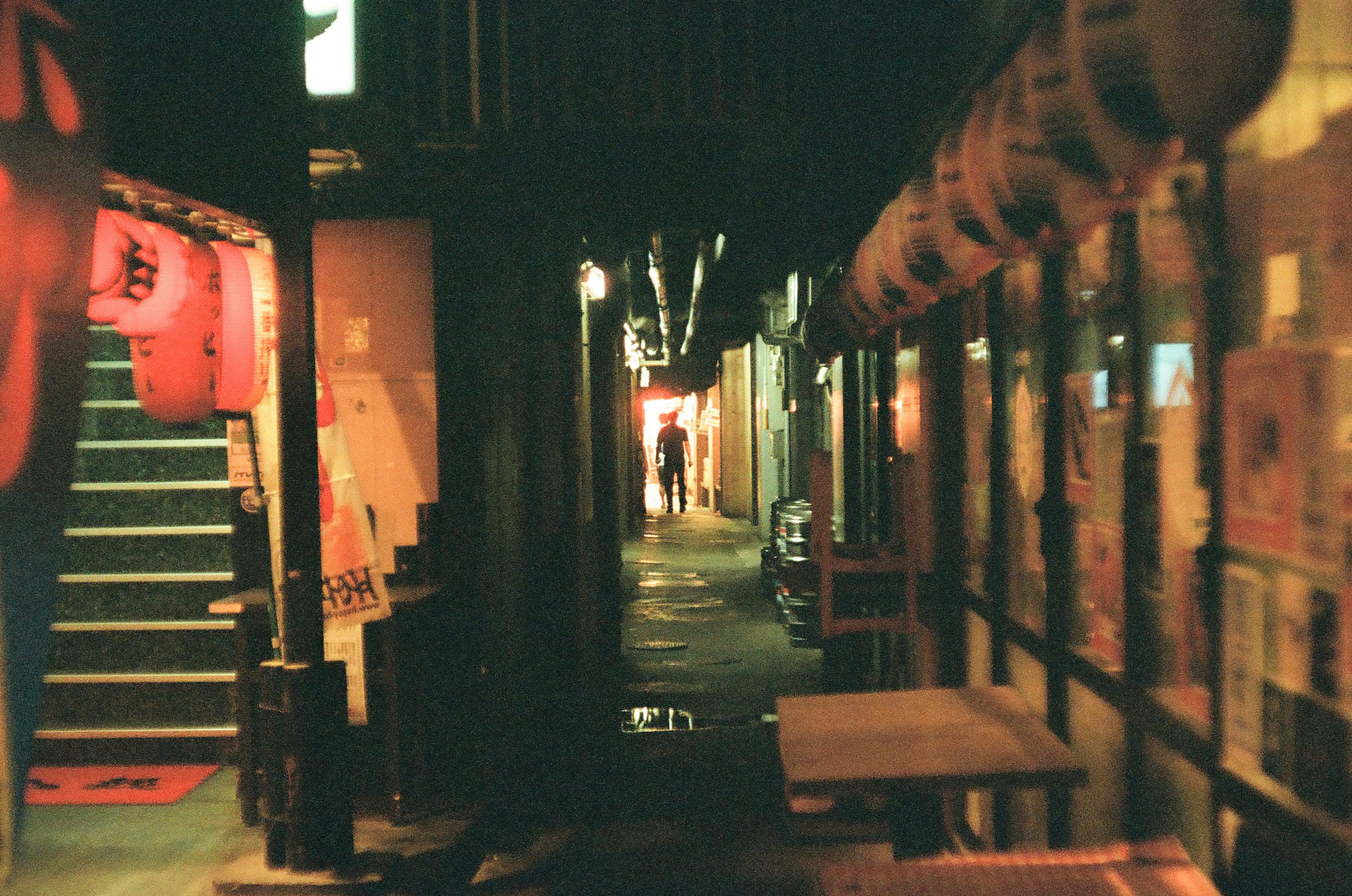 薄暗い路地に並ぶ提灯と階段が特徴的な夜の風景