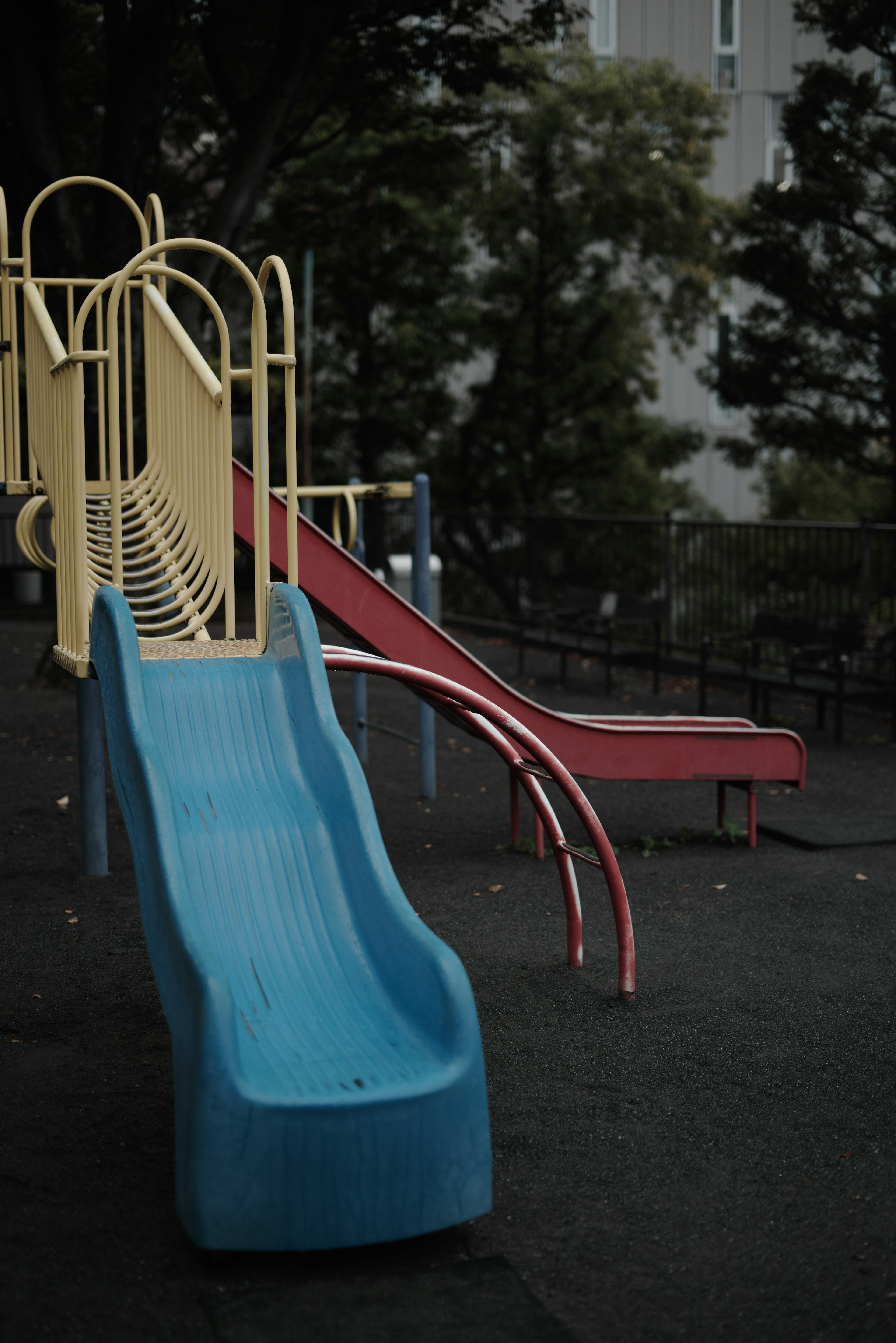 Spielplatz mit blauer Rutsche und roter Rutsche