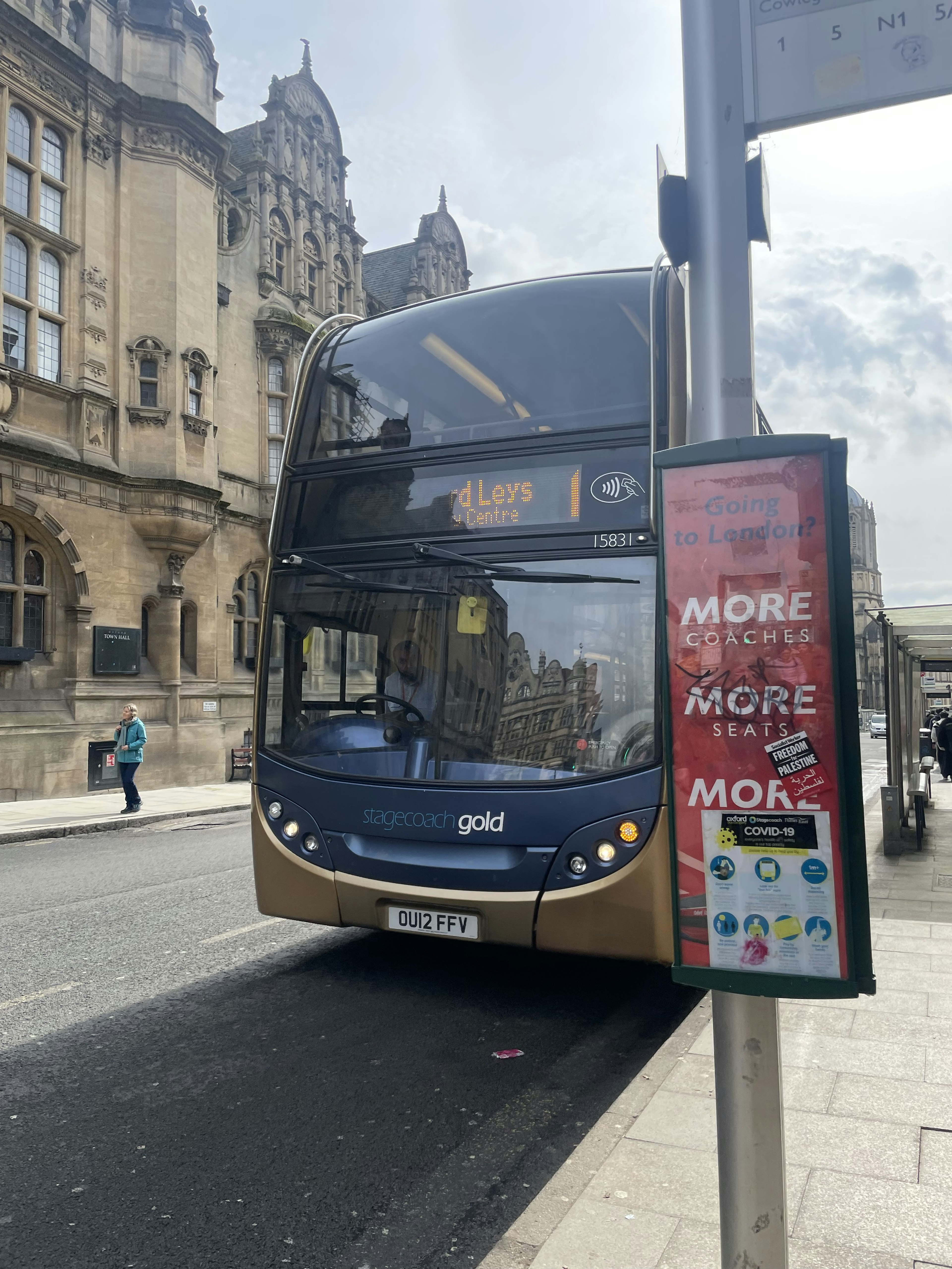 Bus at a stop with a historic building in the background