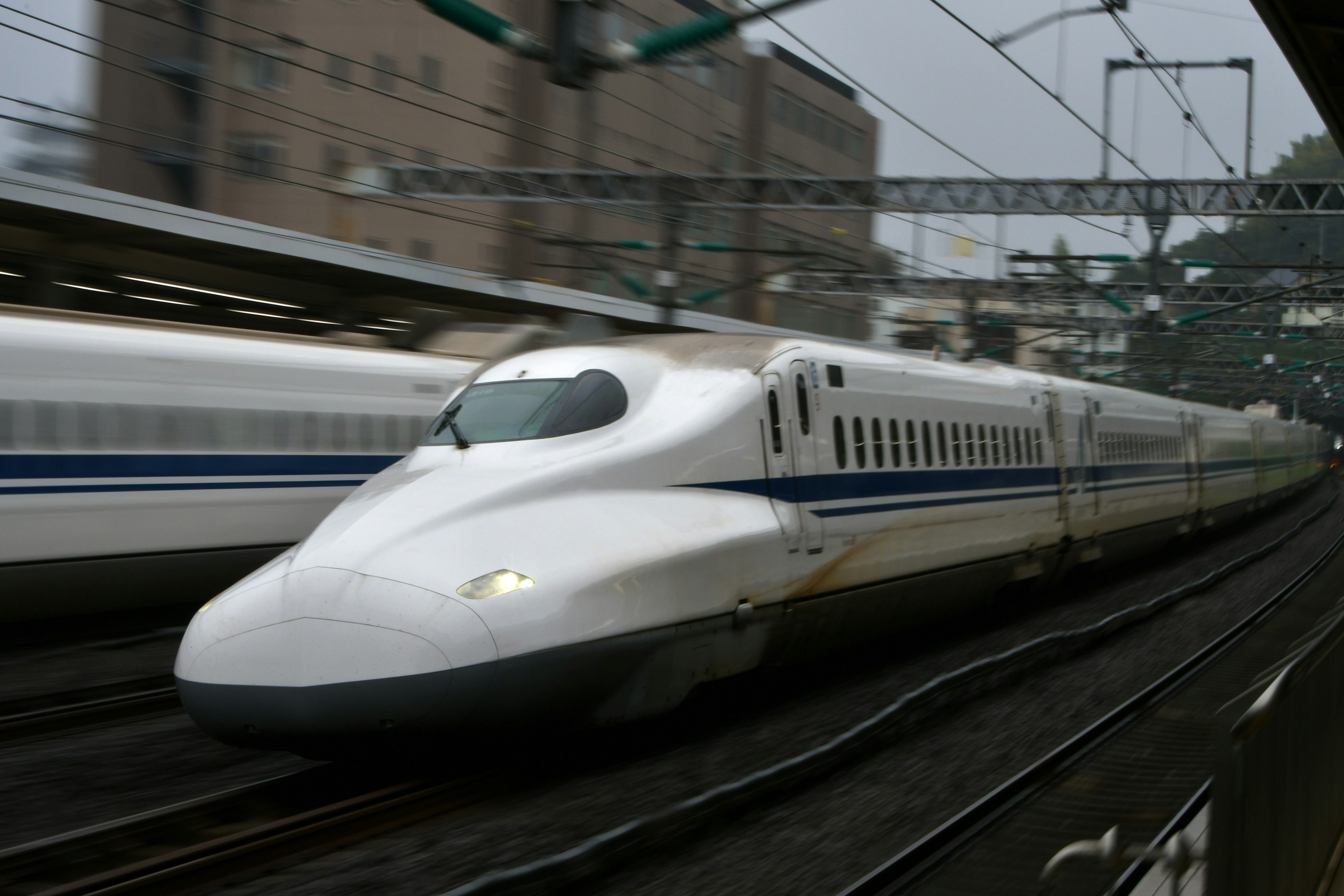 Treno Shinkansen che sfreccia in una stazione